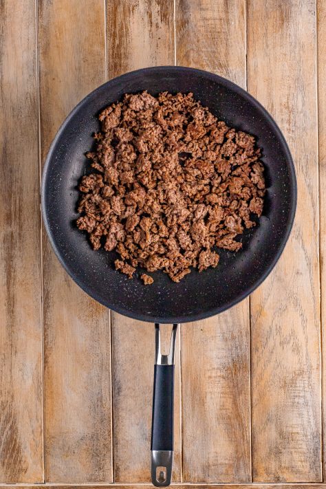 browning and crumbling ground beef in a skillet.