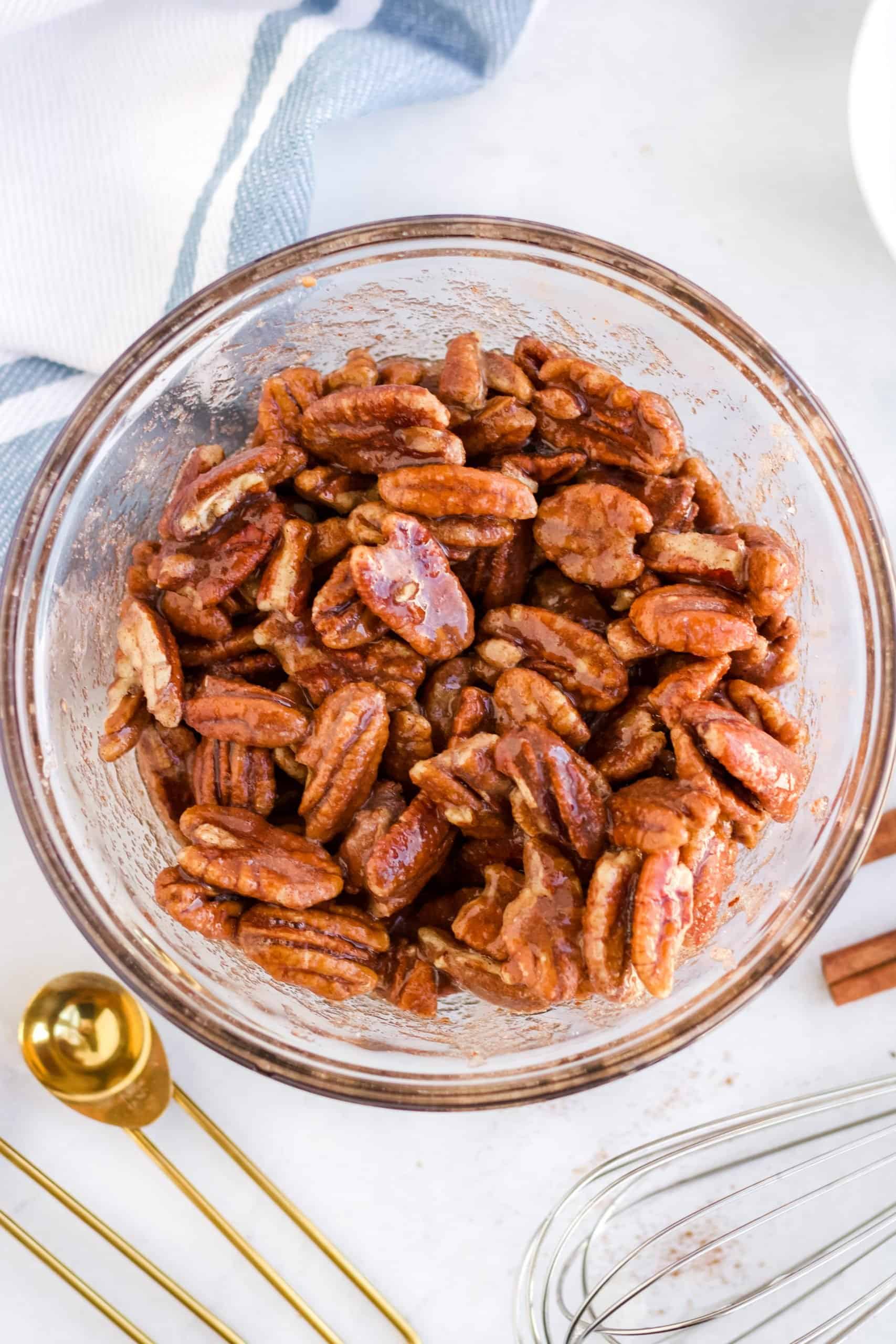 fully coated and seasoned pecan halves in a clear bowl.