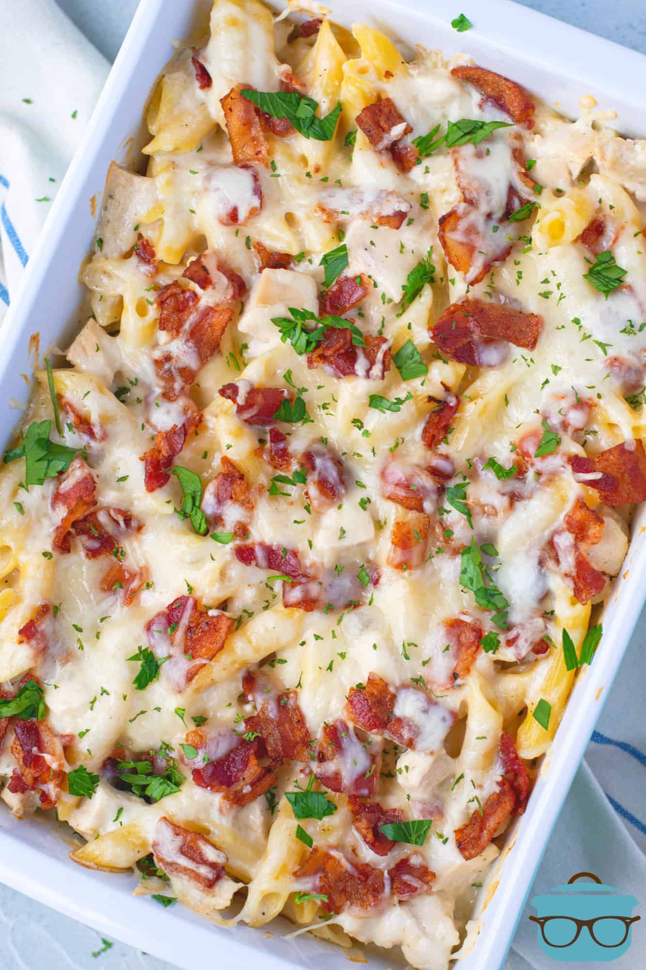 fully baked chicken bacon pasta casserole in a baking dish topped with chopped parsley.