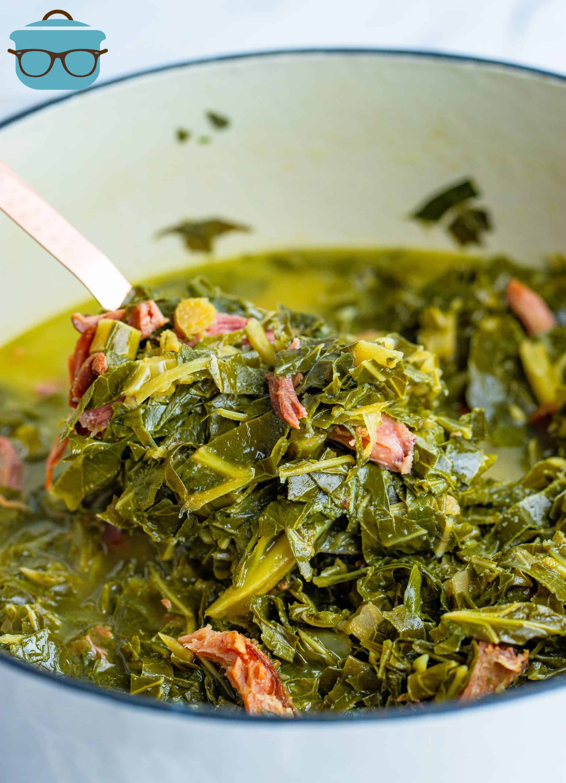 fully cooked collard greens and ham in a white stock pot