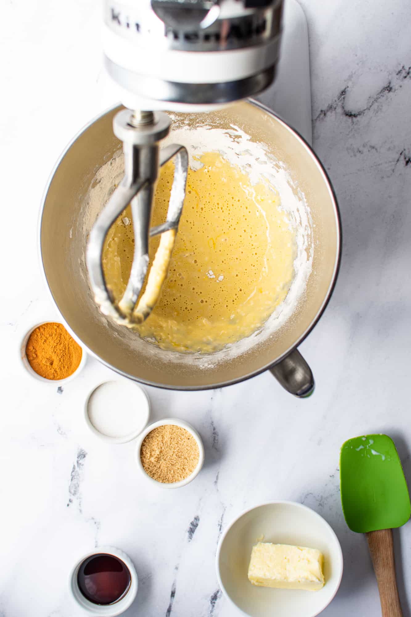 mixing together cinnamon roll batter in a stand mixer