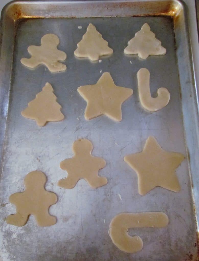 cut out sugar cookie shapes on a steel baking sheet