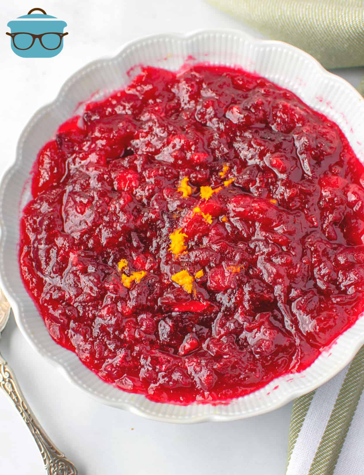 Homemade Cranberry Sauce in a white bowl and topped with fresh orange zest.