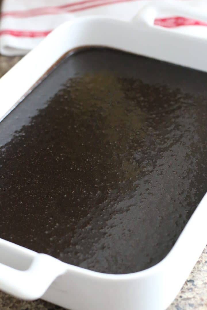 dark chocolate cake batter in a white rectangular baking dish.