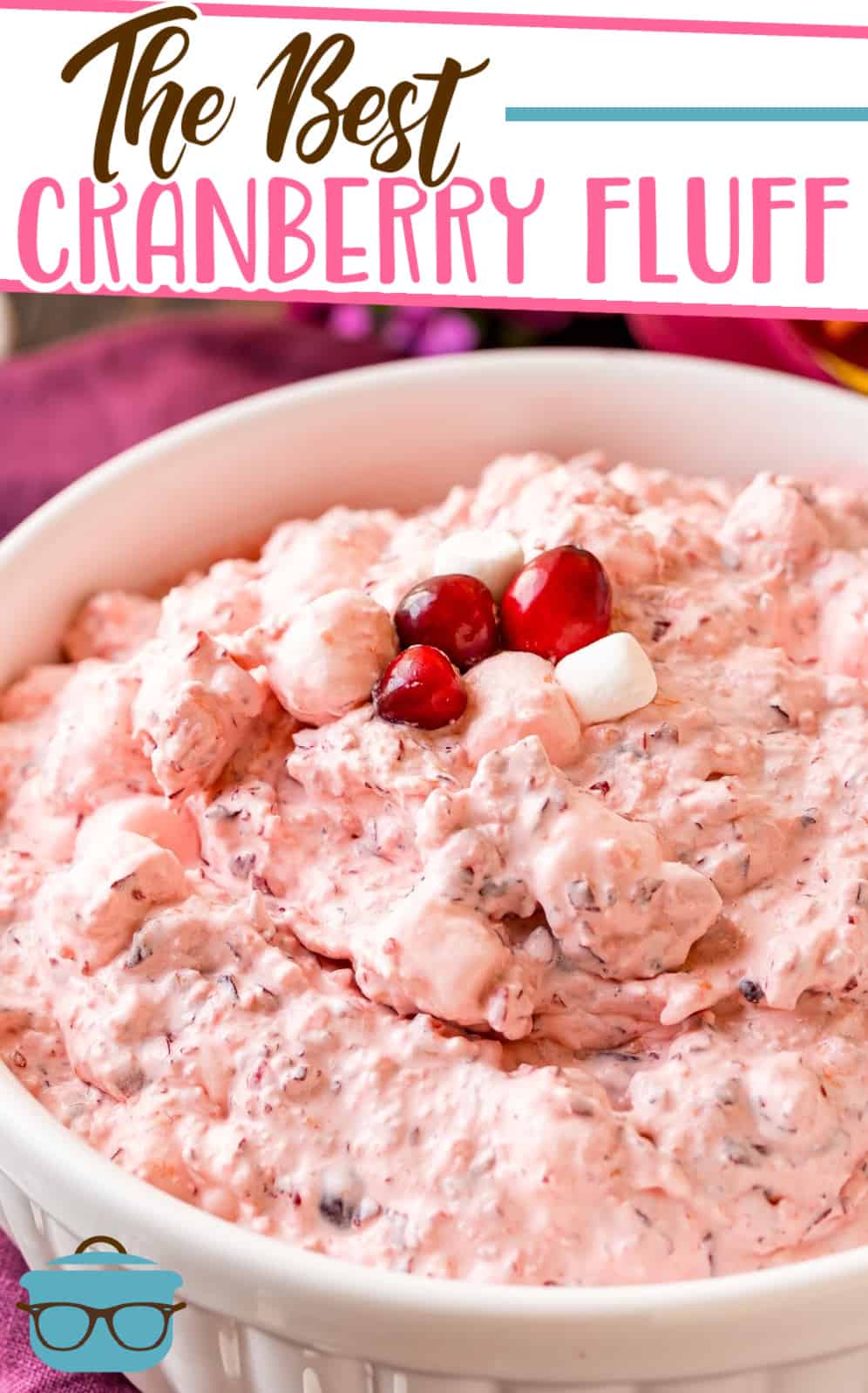 The Best Cranberry Fluff recipe from The Country Cook, shown in a white bowl topped with fresh cranberries and mini marshmallows.