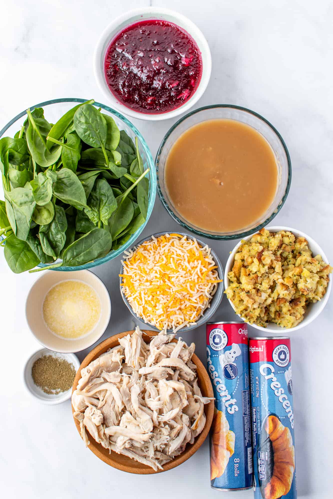 crescent rolls, shredded turkey, stuffing, spinach leaves, cranberry sauce, Monterey Jack cheese, melted butter, poultry seasoning, turkey gravy