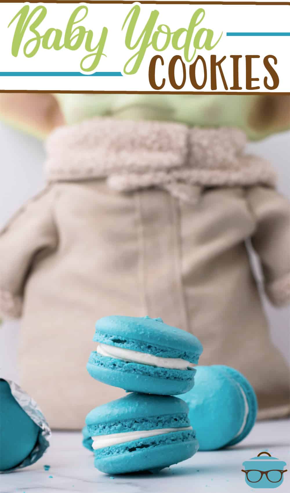 Baby Yoda Cookie recipe (Space Macarons) from The Country Cook, Baby Yoda doll standing up behind teal blue macarons that are stacked two high.