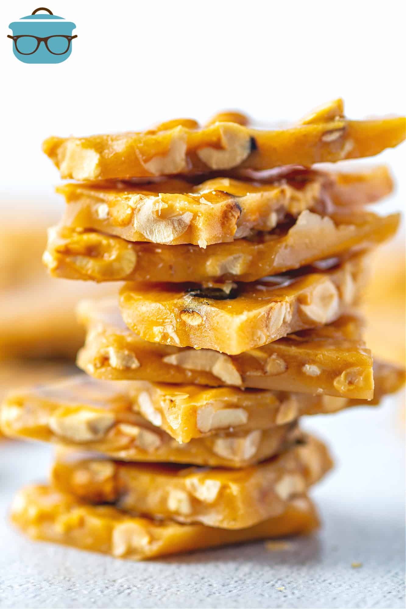 Homemade Peanut Brittle Candy pieces shown stacked in a pile.