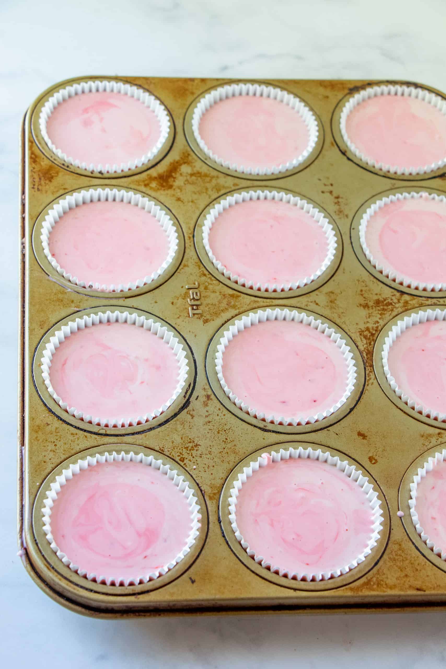 peppermint cheesecake filling added into cupcake liners in a muffin tin.