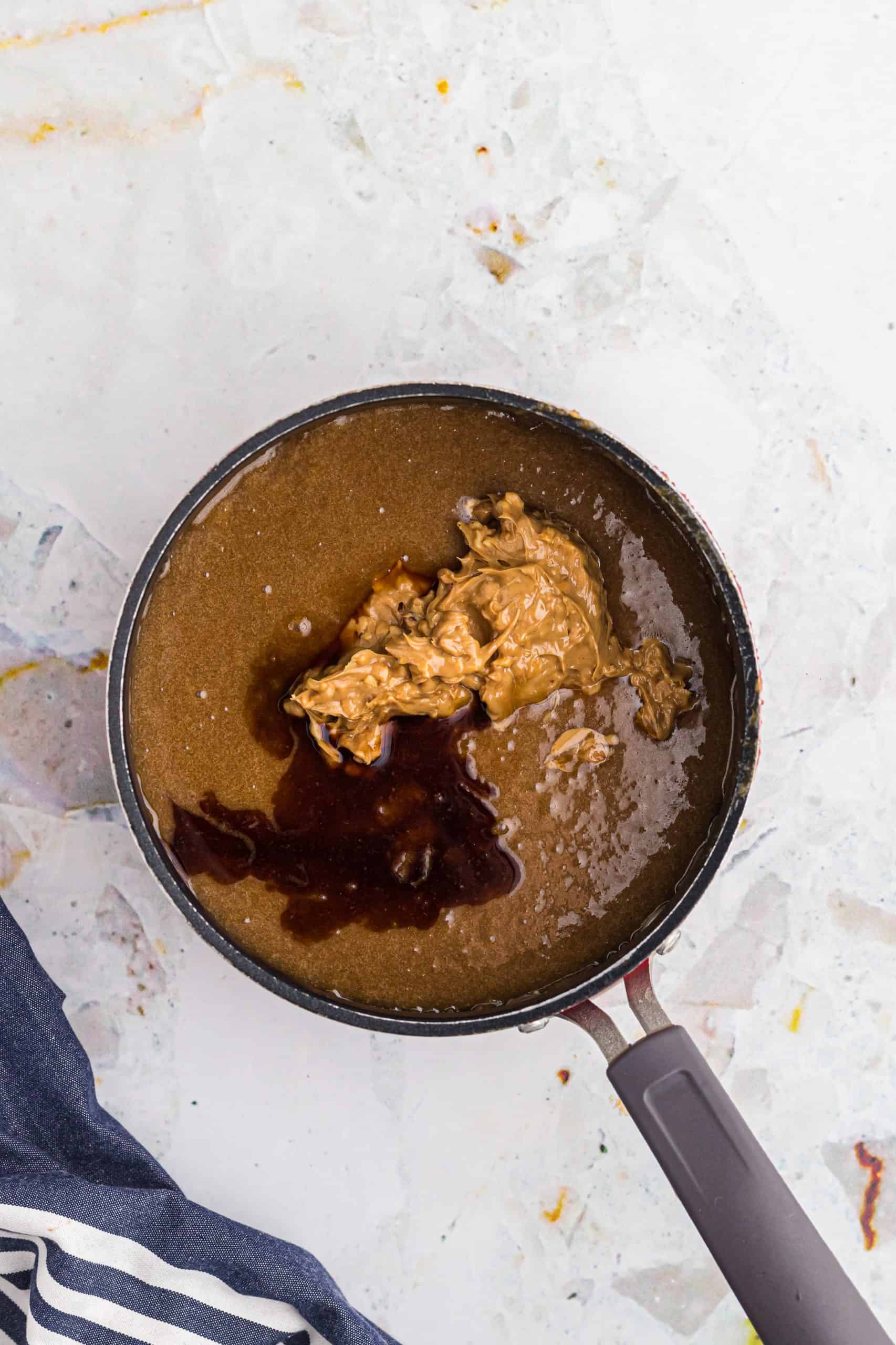 crunchy peanut butter and vanilla extract added to brown sugar mixture in a sauce pan.