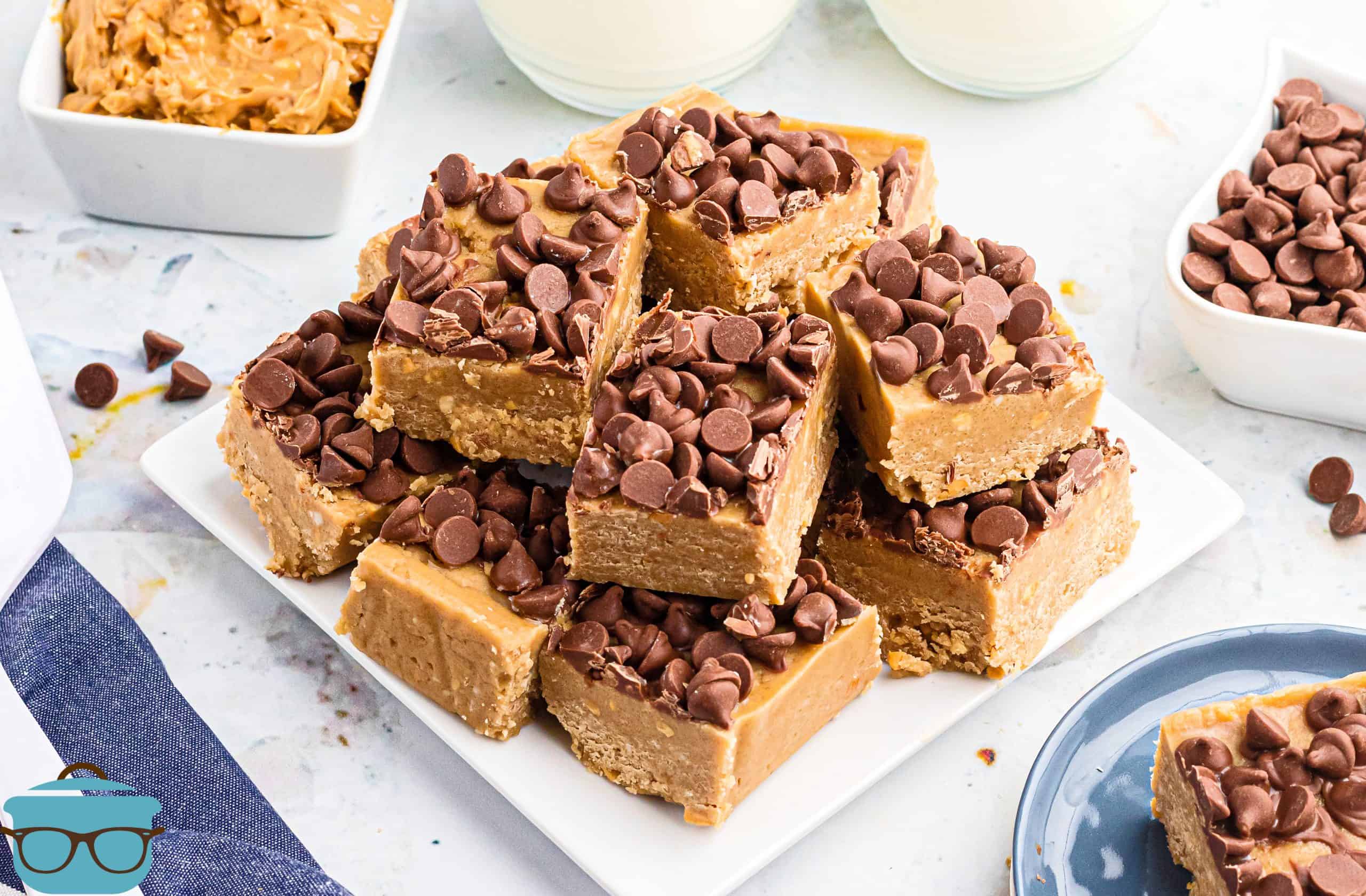 slices of peanut butter fudge stacked on a white square plate.