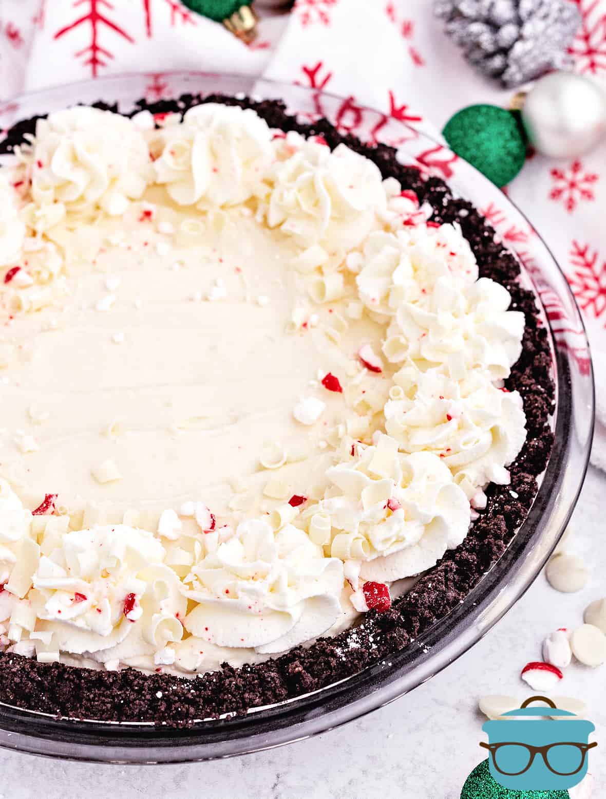 Peppermint Pie with decorated edges and Christmas ornaments on the side.