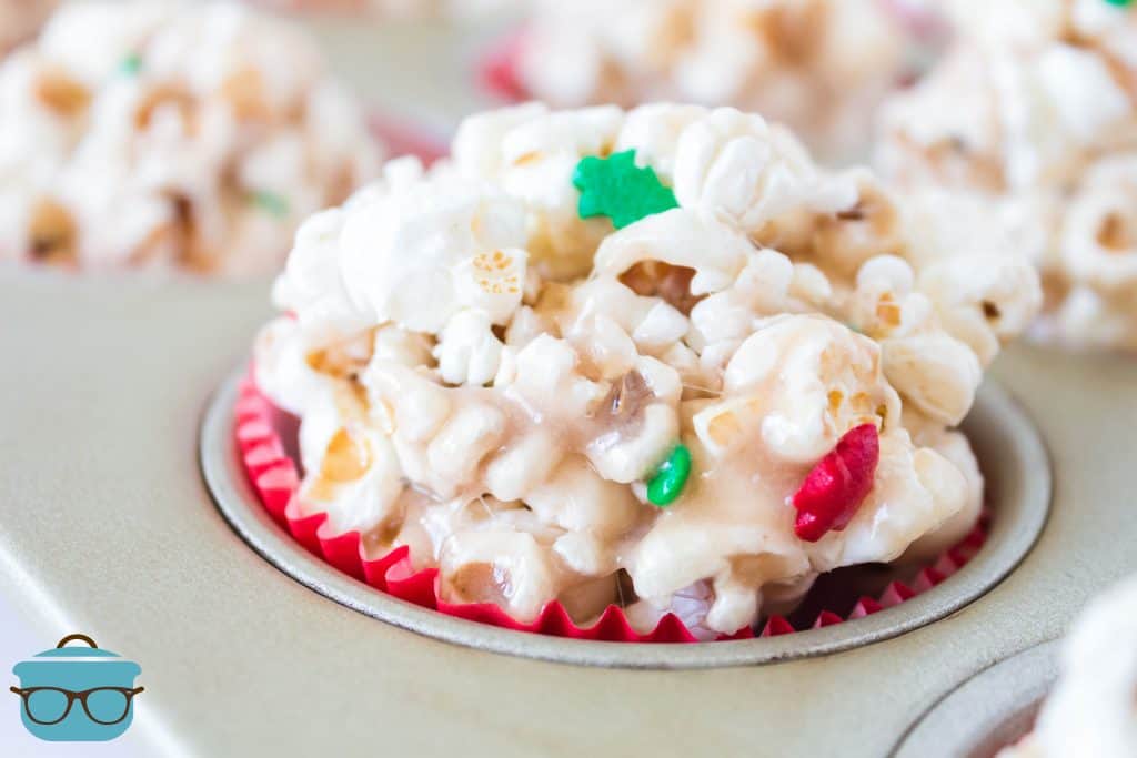 close up shot of popcorn balls in red cupcake liners in a muffin tin