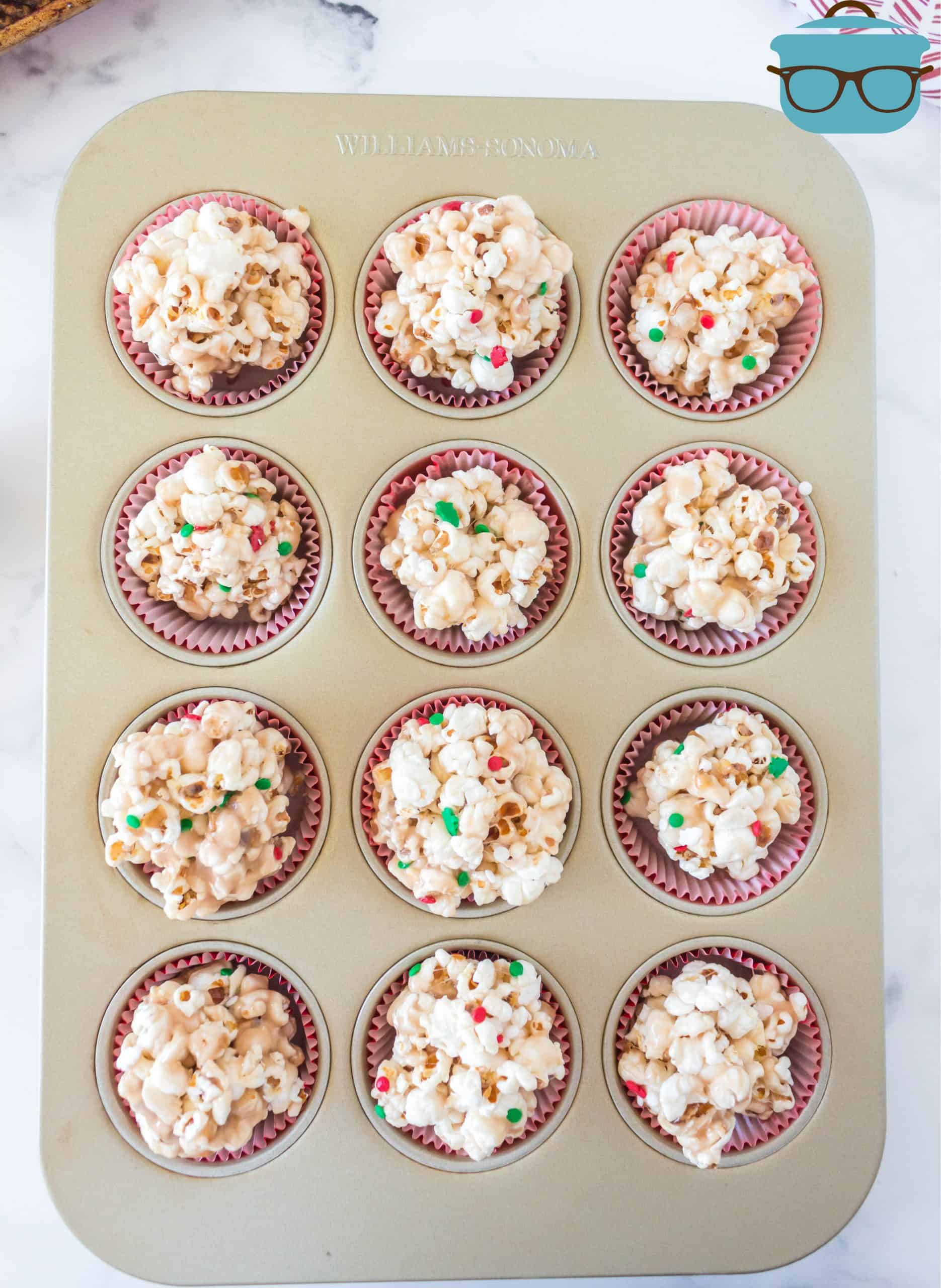 finished popcorn balls in muffin liners in a muffin baking pan.
