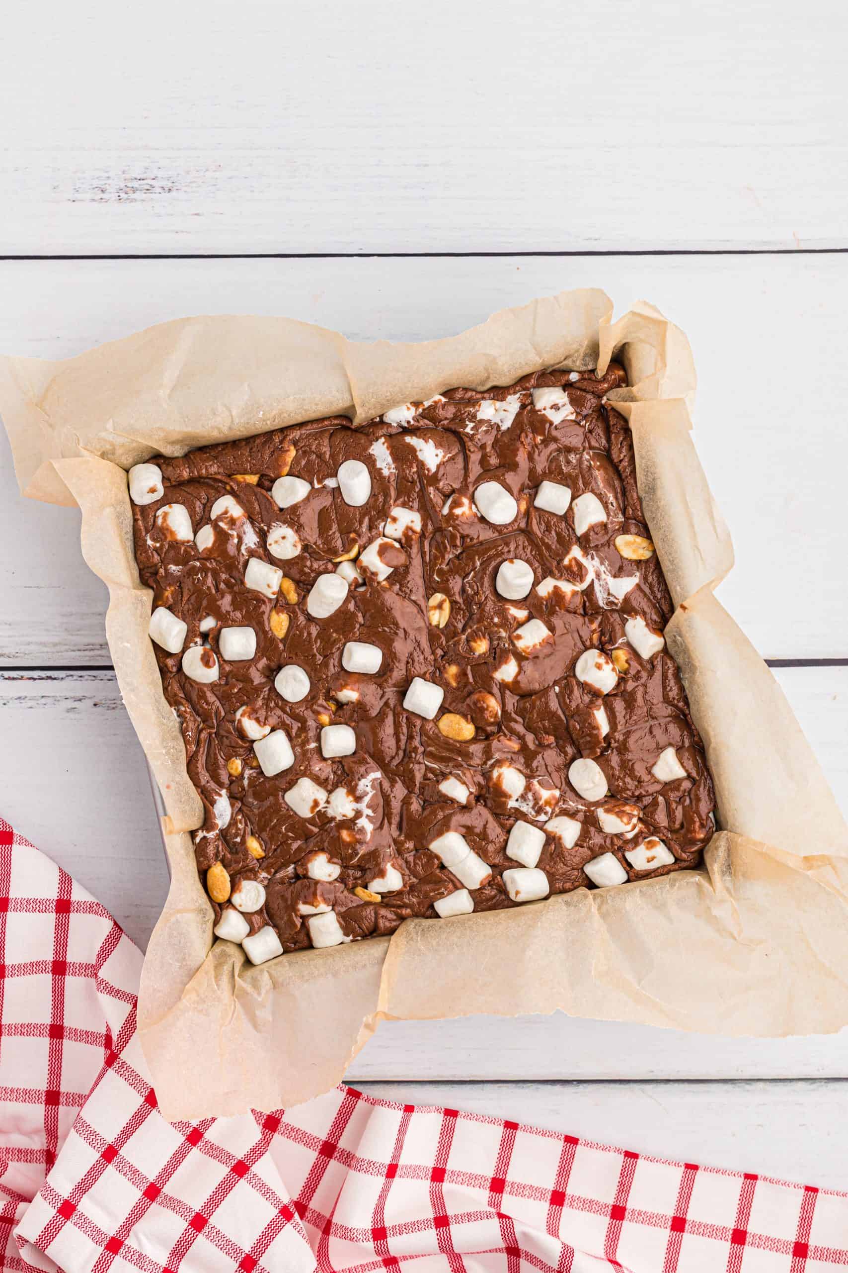 rocky road fudge batter poured into parchment paper lined baking dish.