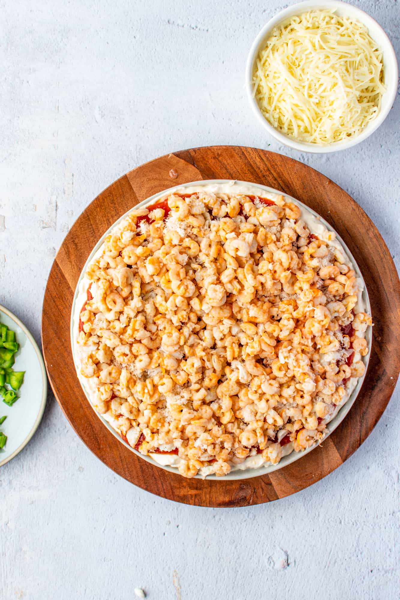 tiny shrimp spread evenly onto crab meat inside a large white platter.
