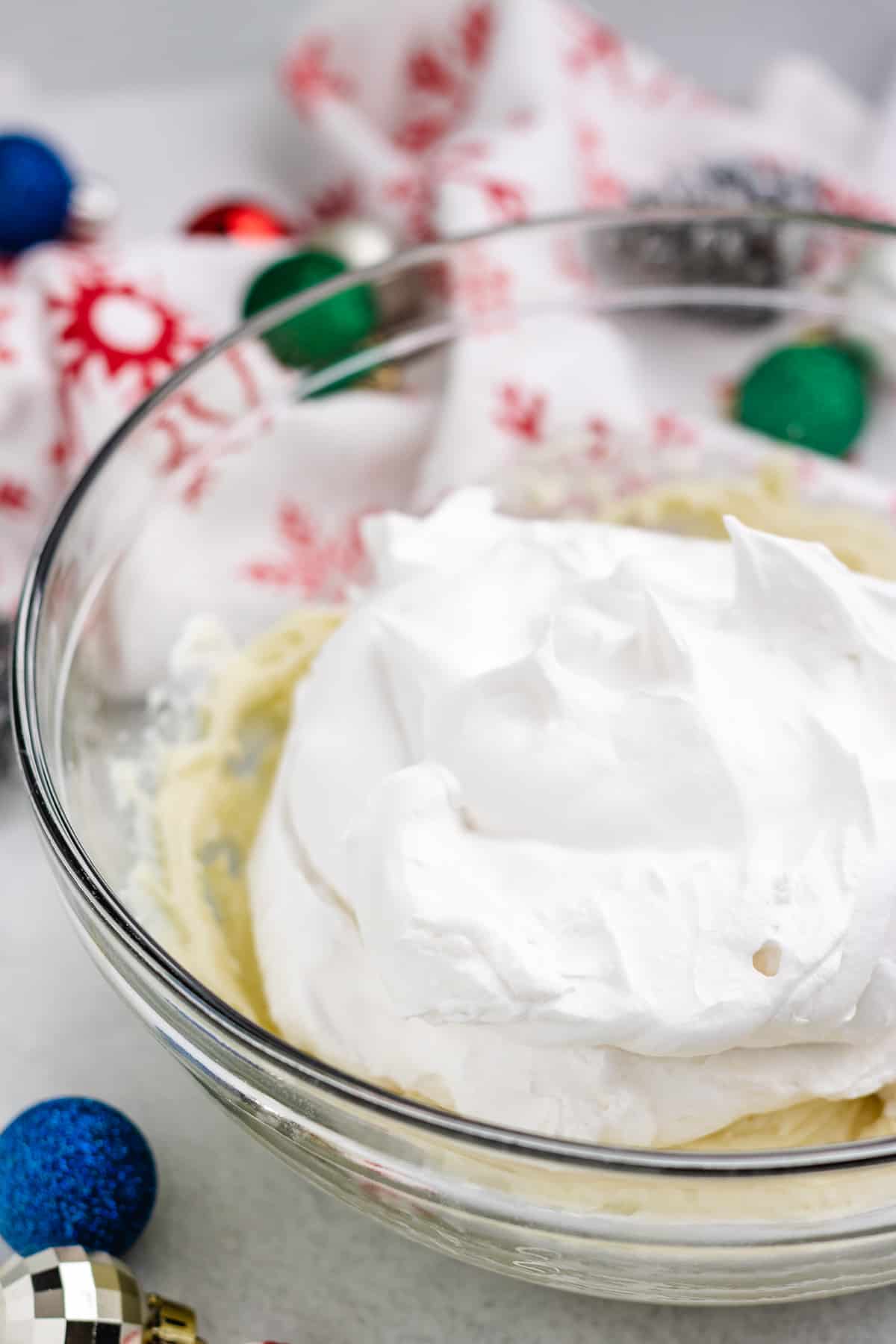 whipped topping added into the bowl that contains cream cheese and melted white chocolate.