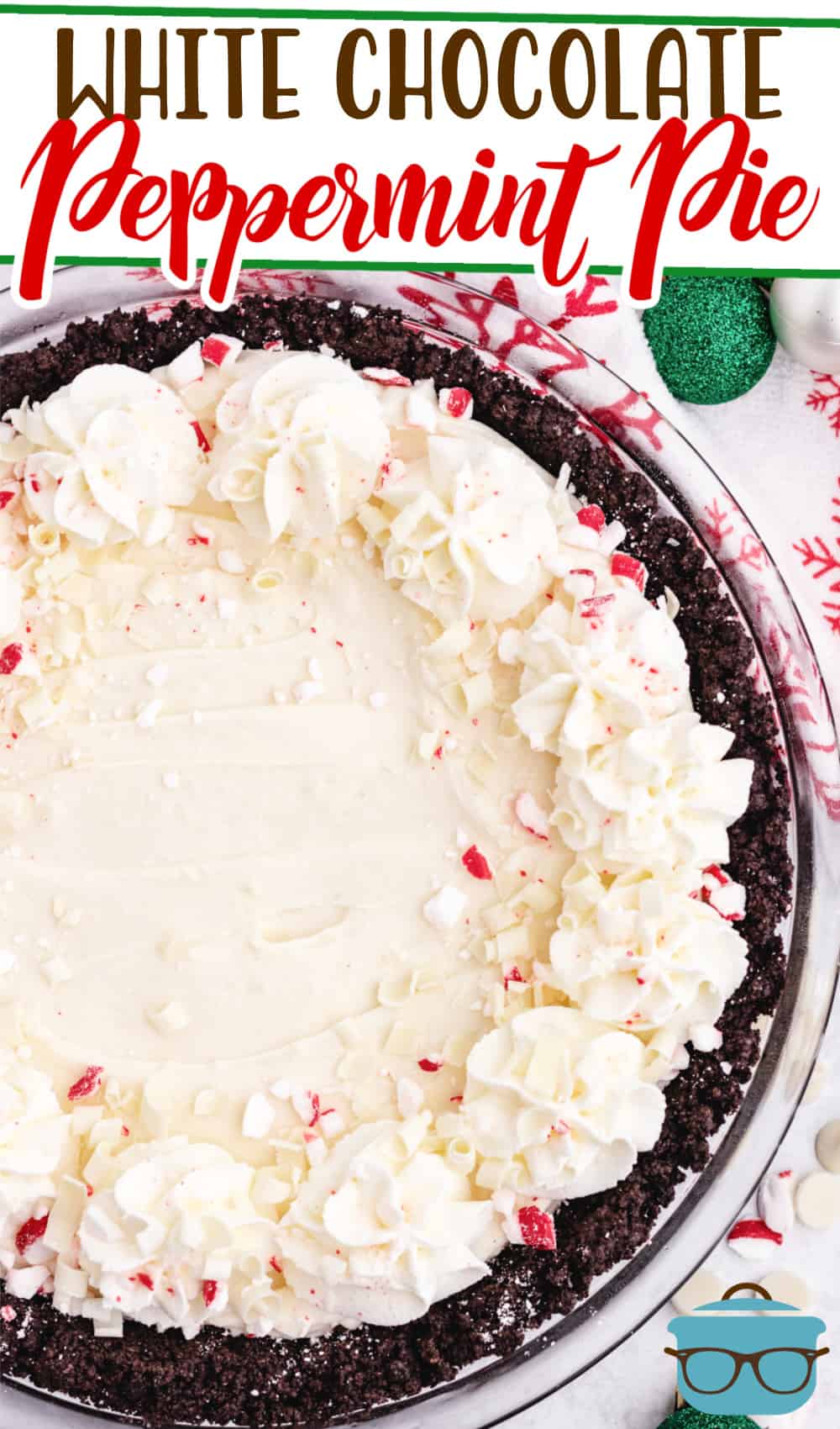 White Chocolate Peppermint Pie with Oreo Cookie Crust recipe from The Country Cook, whole pie showin with Christmas tree ornaments on the side.