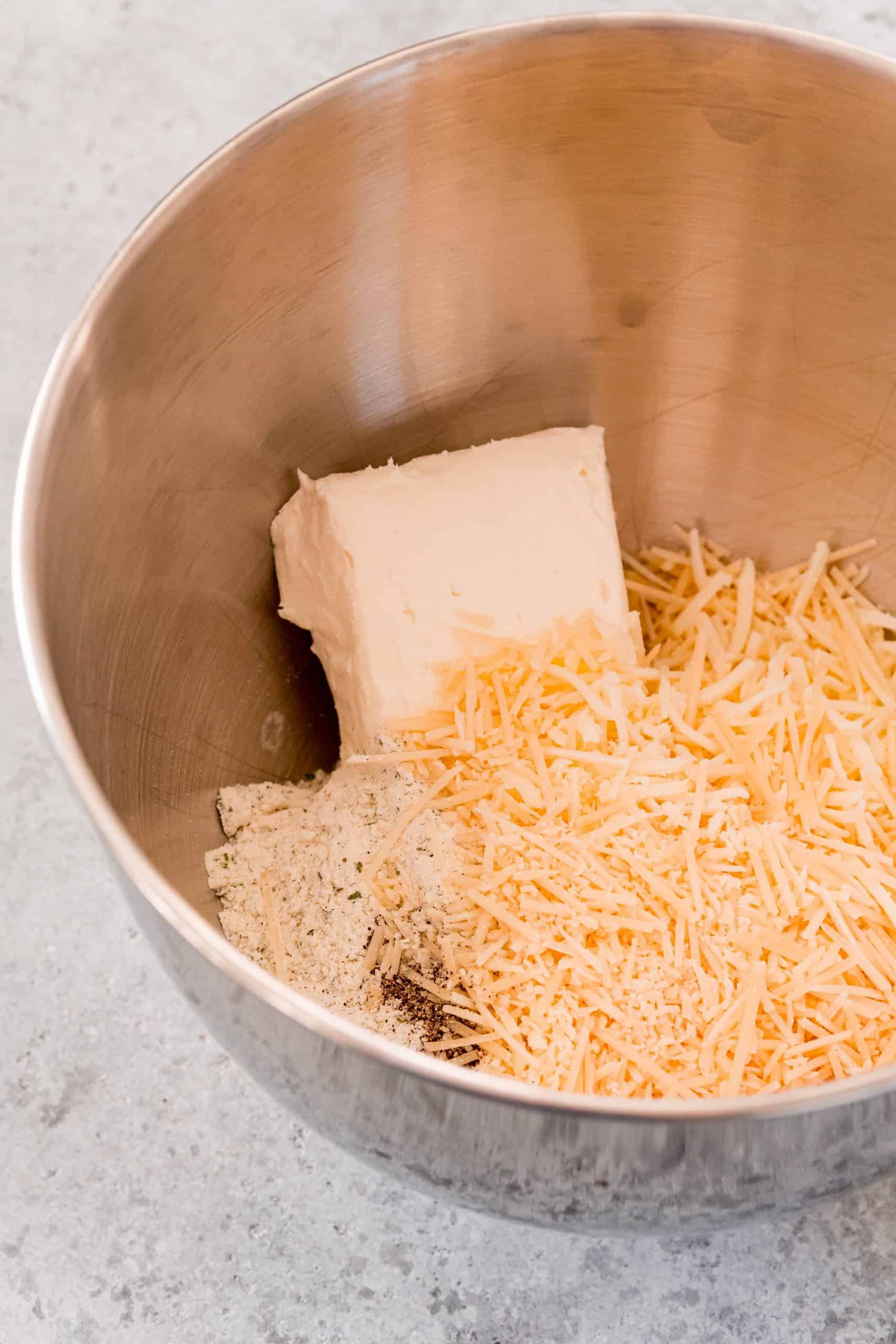 Cream cheese, cheese and spice in stand mixer bowl.