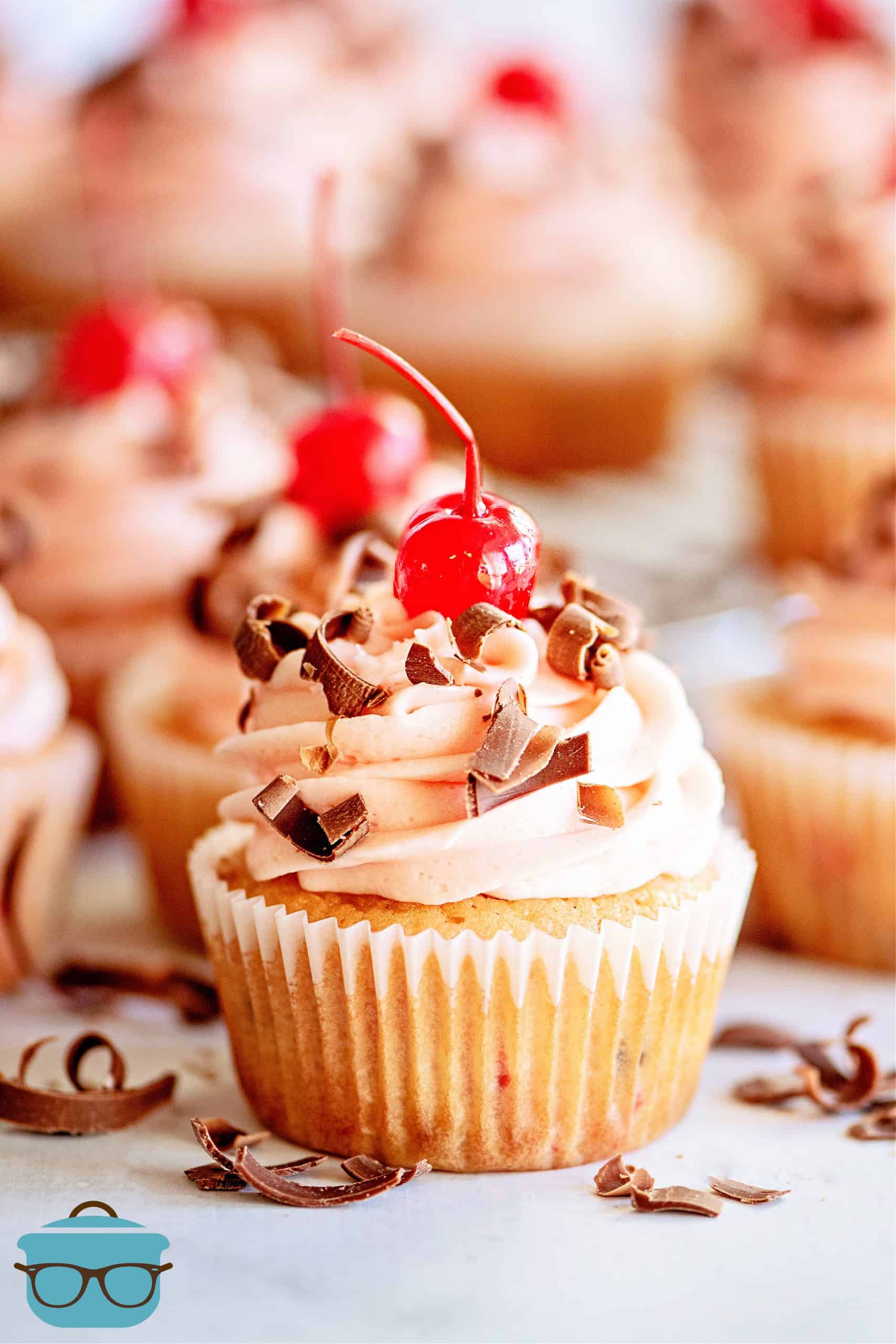 Close up of one Cherry Chocolate Chip Cupcake topped with cherry and chocolate. 
