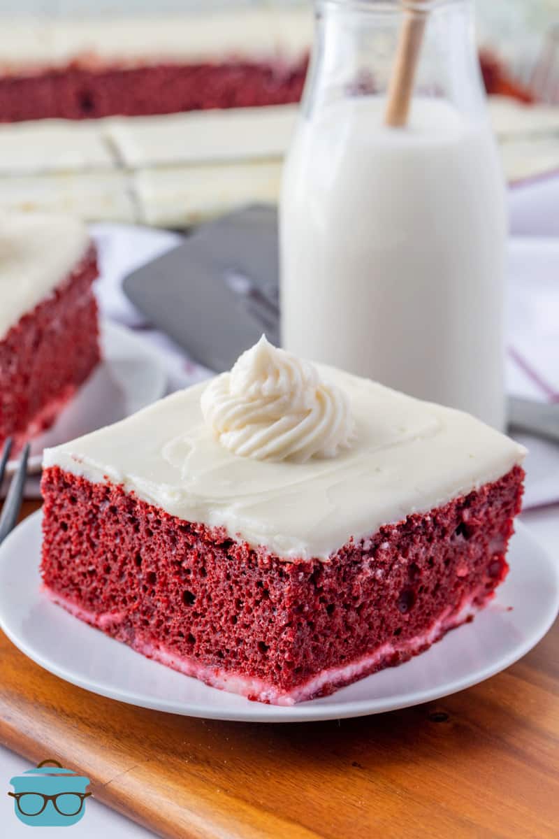 a slice of red velvet cheesecake cake on a round white plate. 