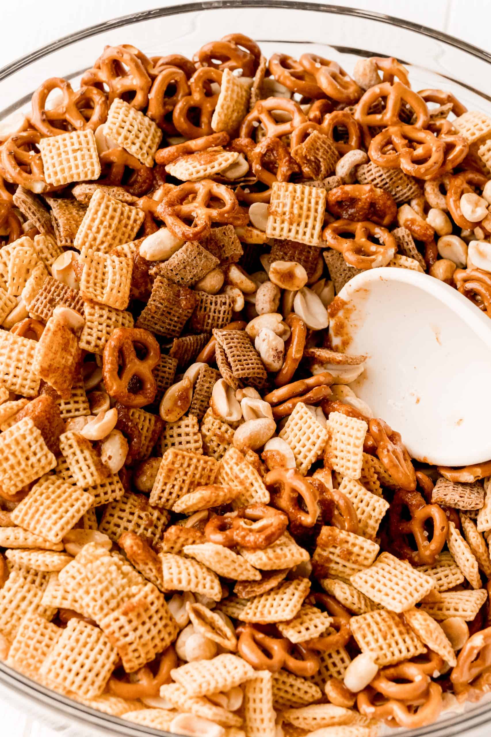 Butter and spices added to Chex mix being stirred
