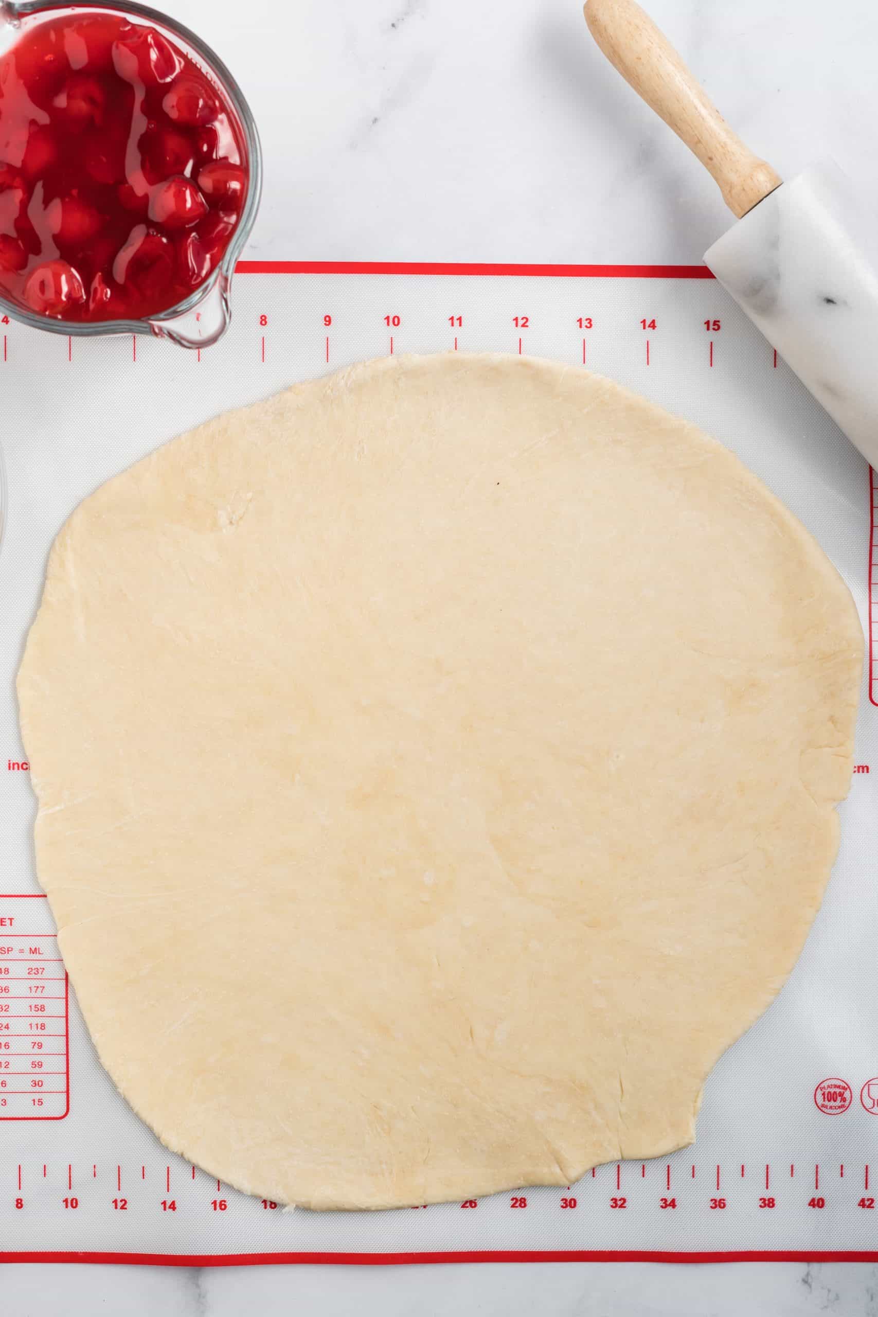 pizza dough rolled flat into a 12-inch circle on a pie crust mat.