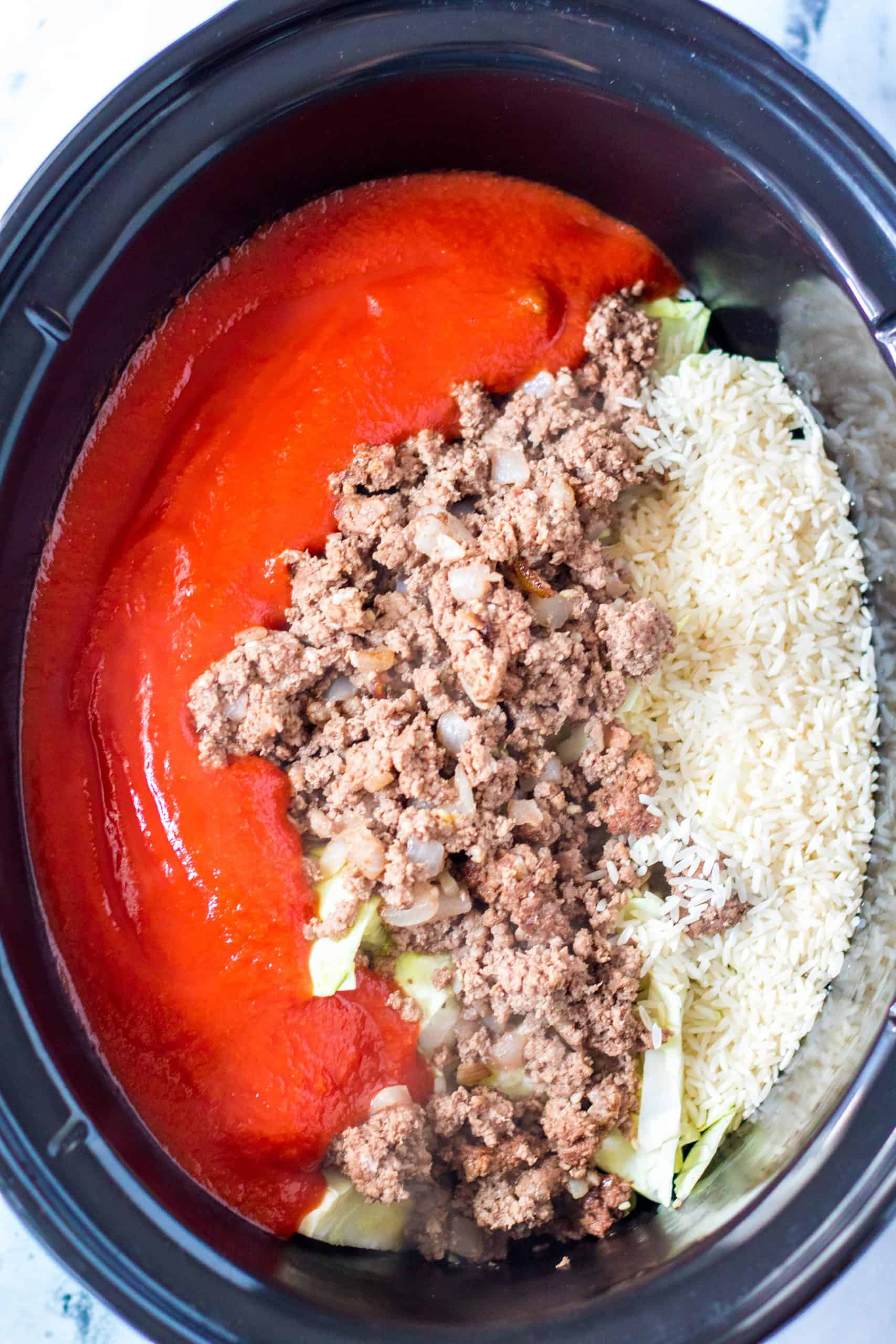 cooked ground beef, rice and tomato sauce in crock pot.