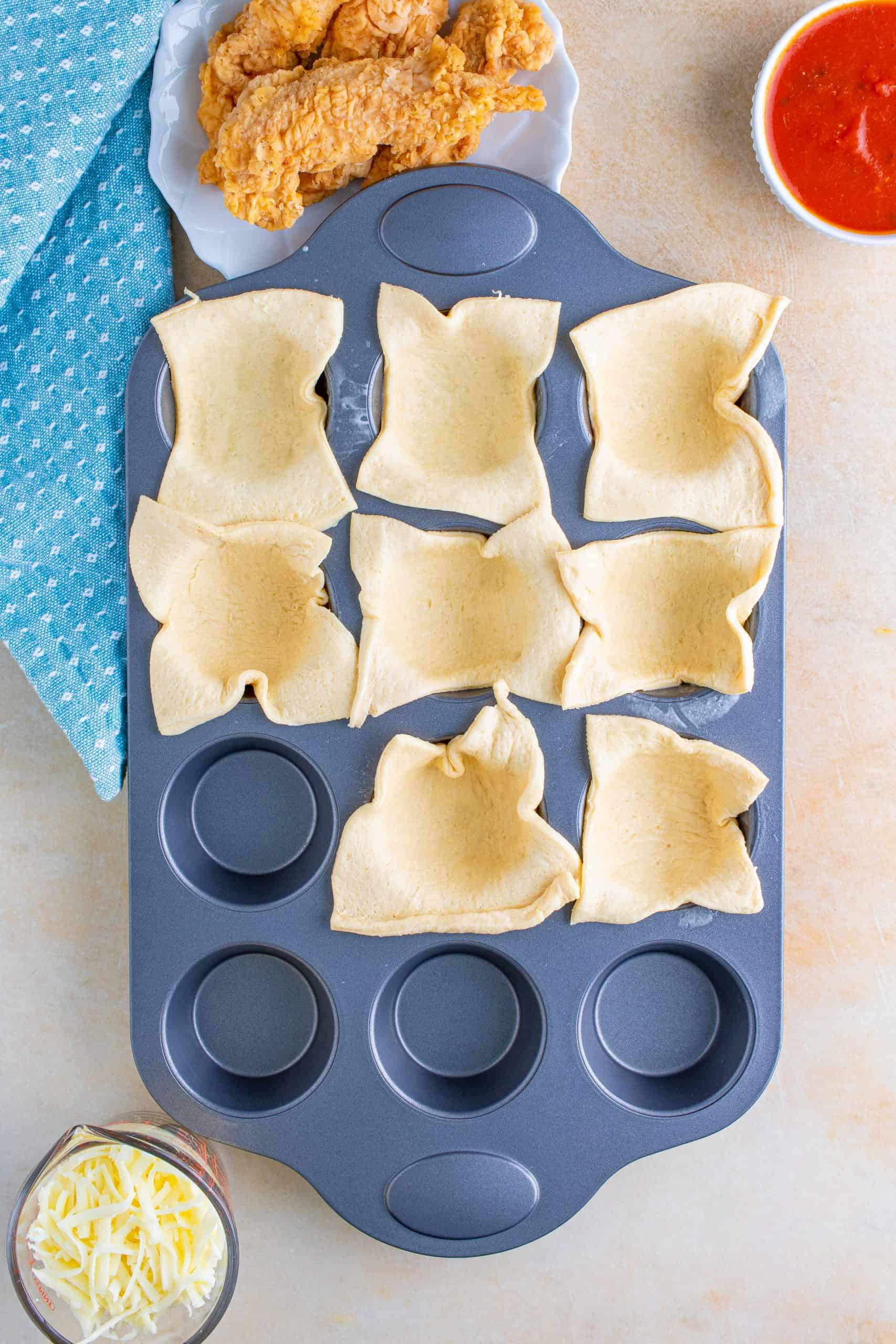 Cut crescent rolls in muffin tin.