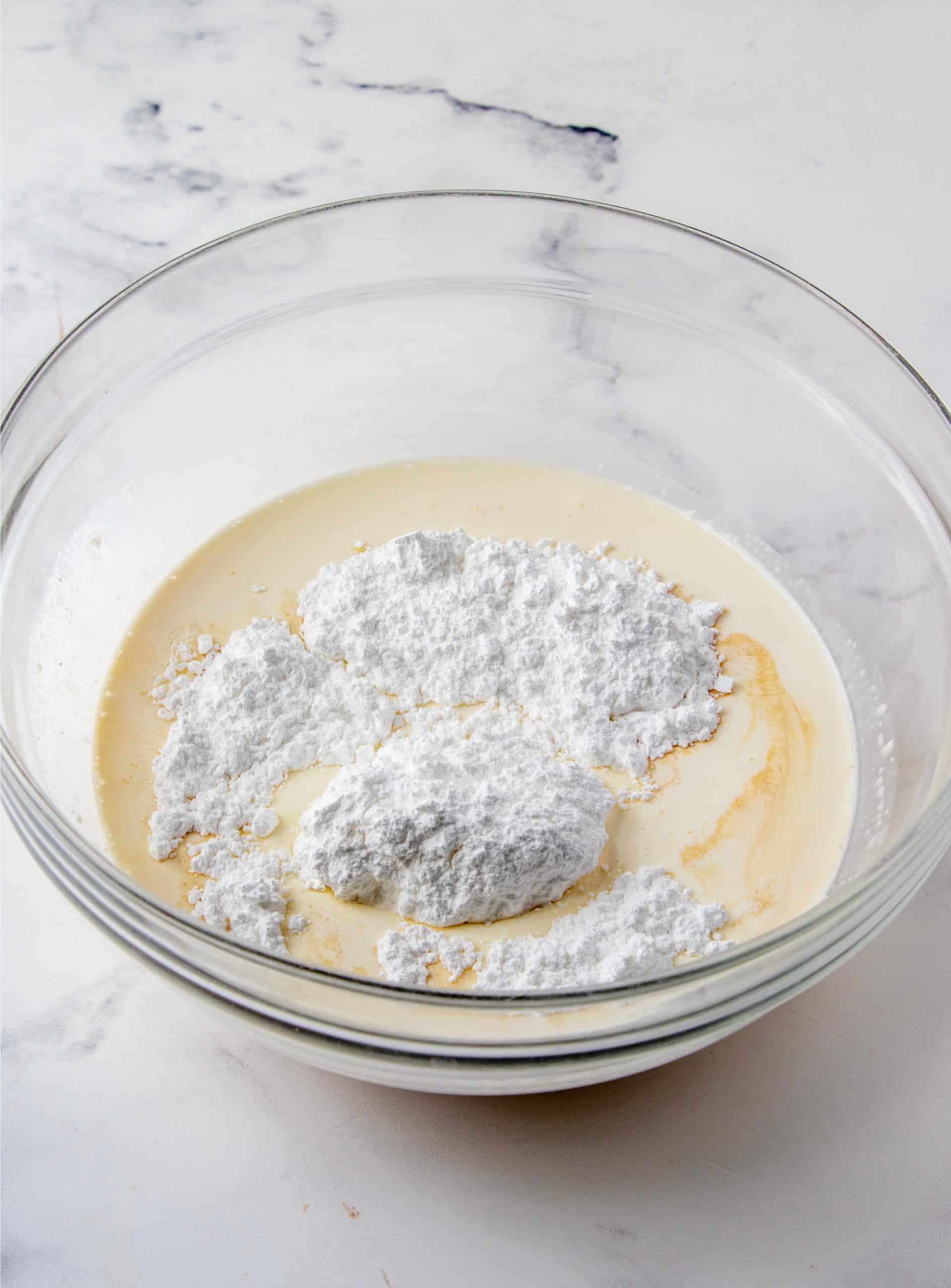 Heavy cream, bailey's and powdered sugar in bowl.