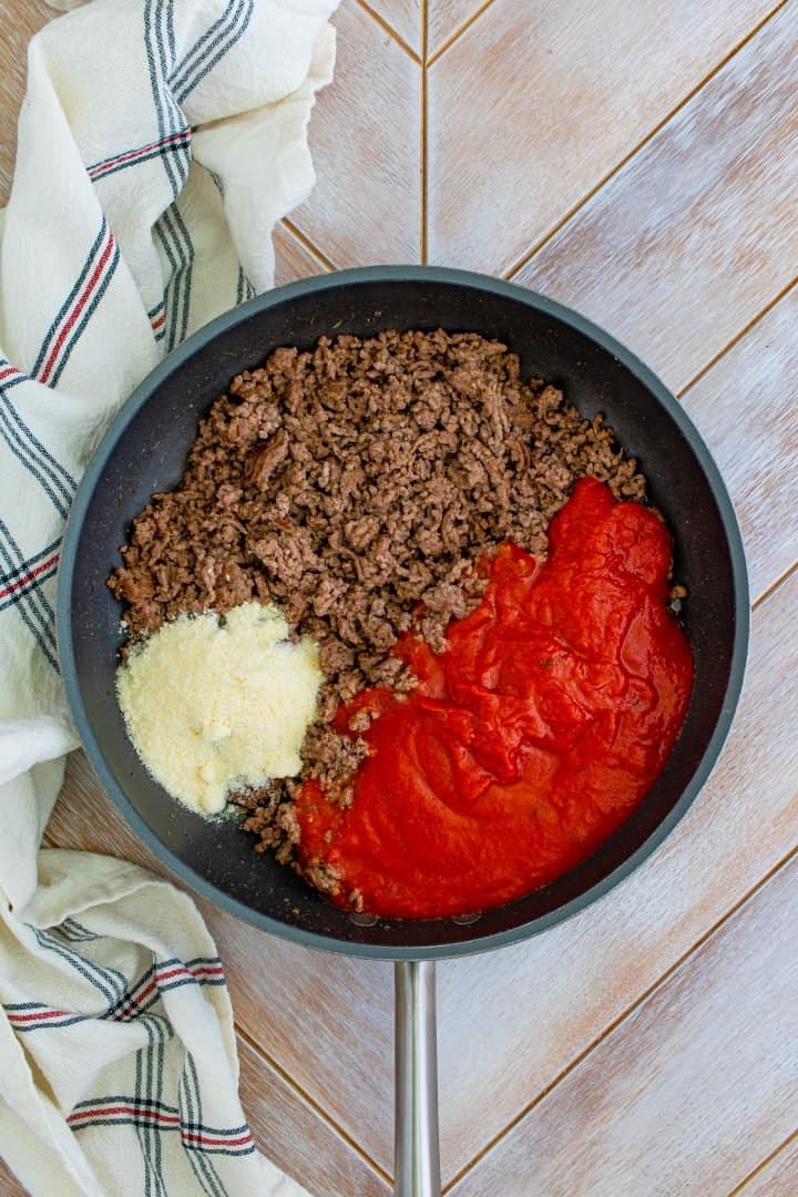 Ground beef, sauce and parmesan in a skillet.