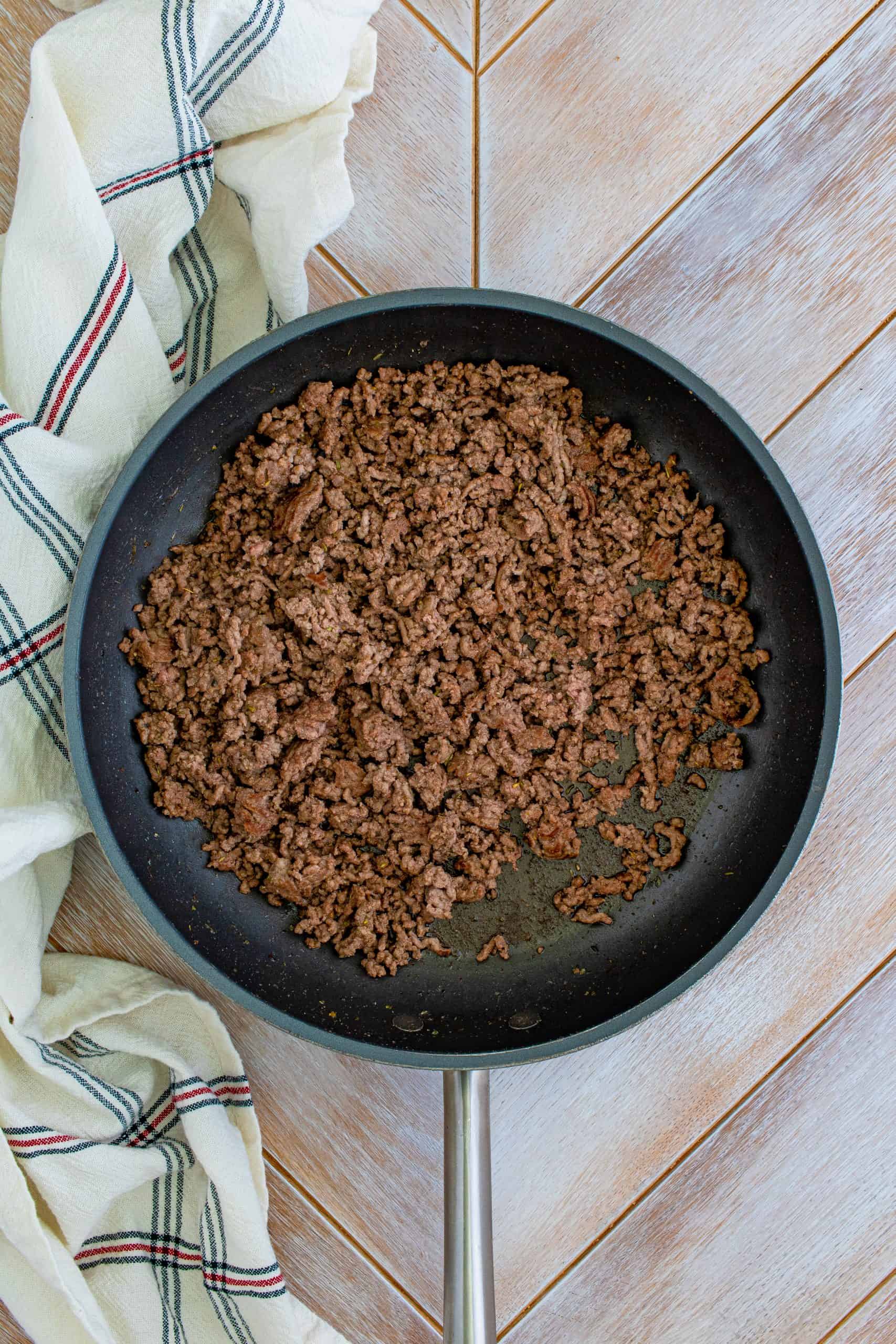 Ground beef cooked in pan.