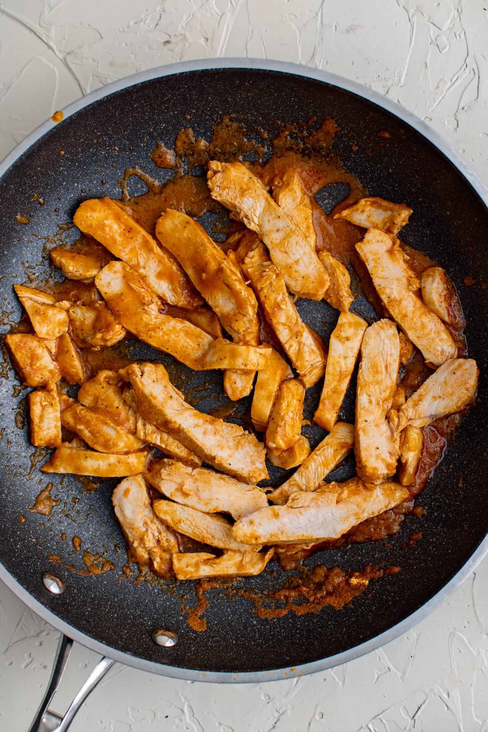 Sliced up chicken in pan.
