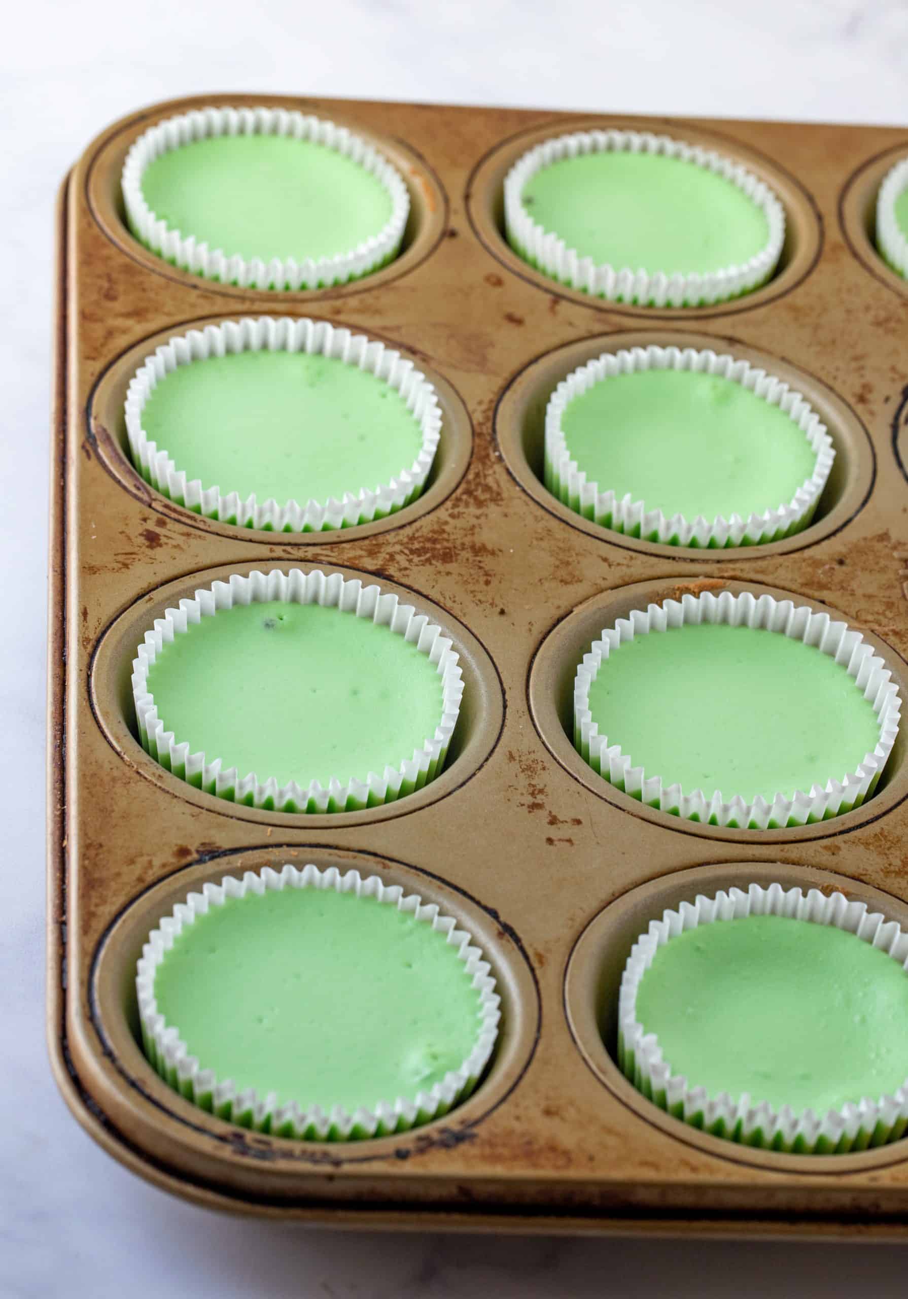 Baked Mini Mint Chocolate Cheesecakes in muffin tin.