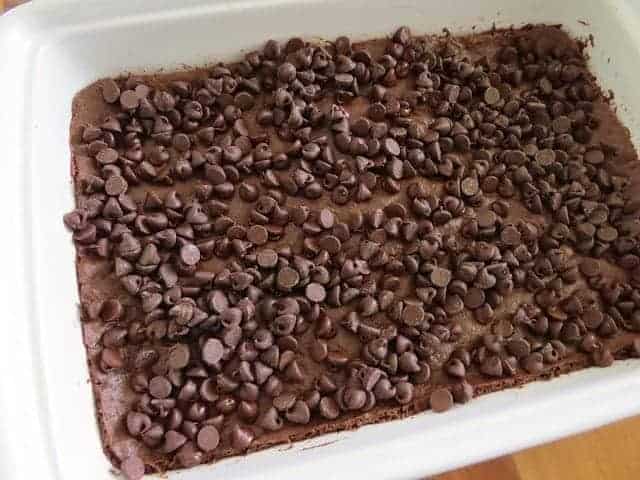 chocolate chips on top of brownie batter in a baking dish.