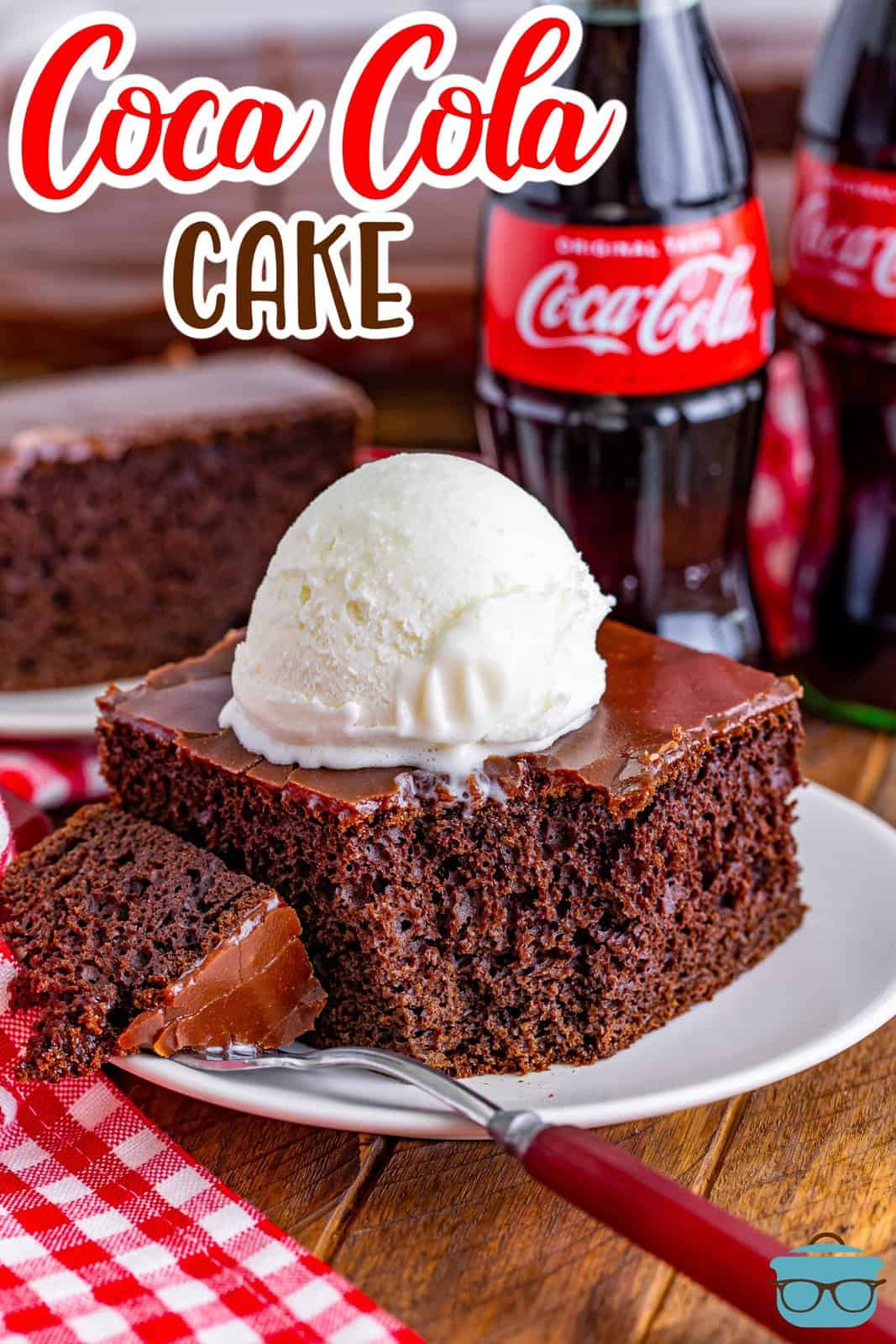 a slice of Coca Cola cake on a small white plate with a bite removed and topped with a scoop of vanilla ice cream. 