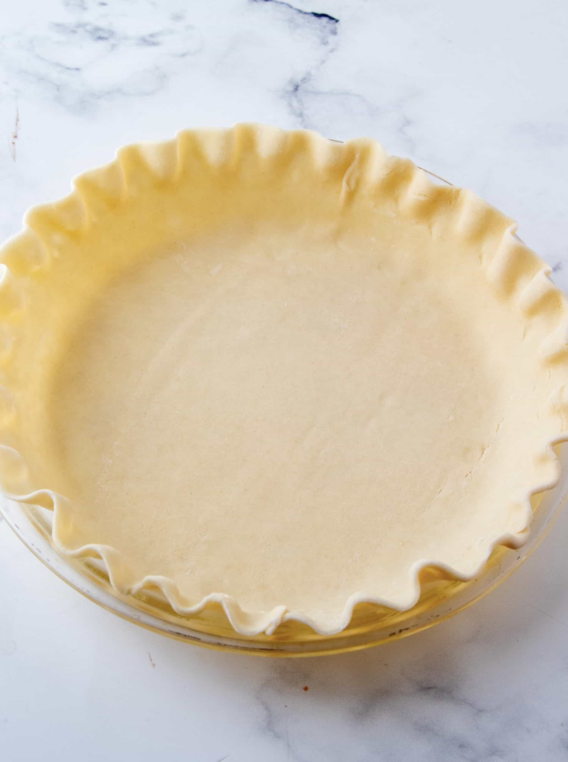 Pie crust in pie plate with edges fluted.