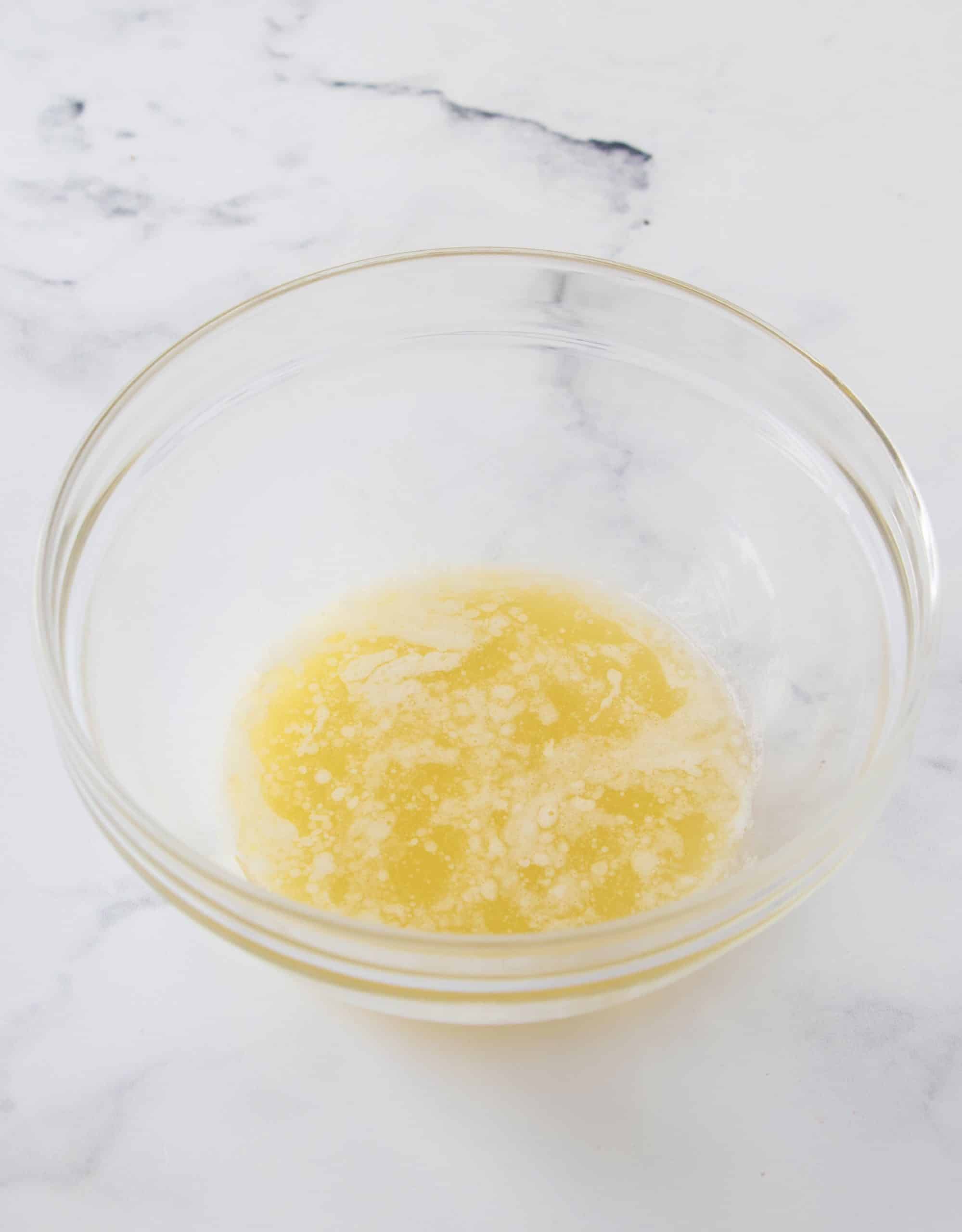Melted butter in a clear bowl.