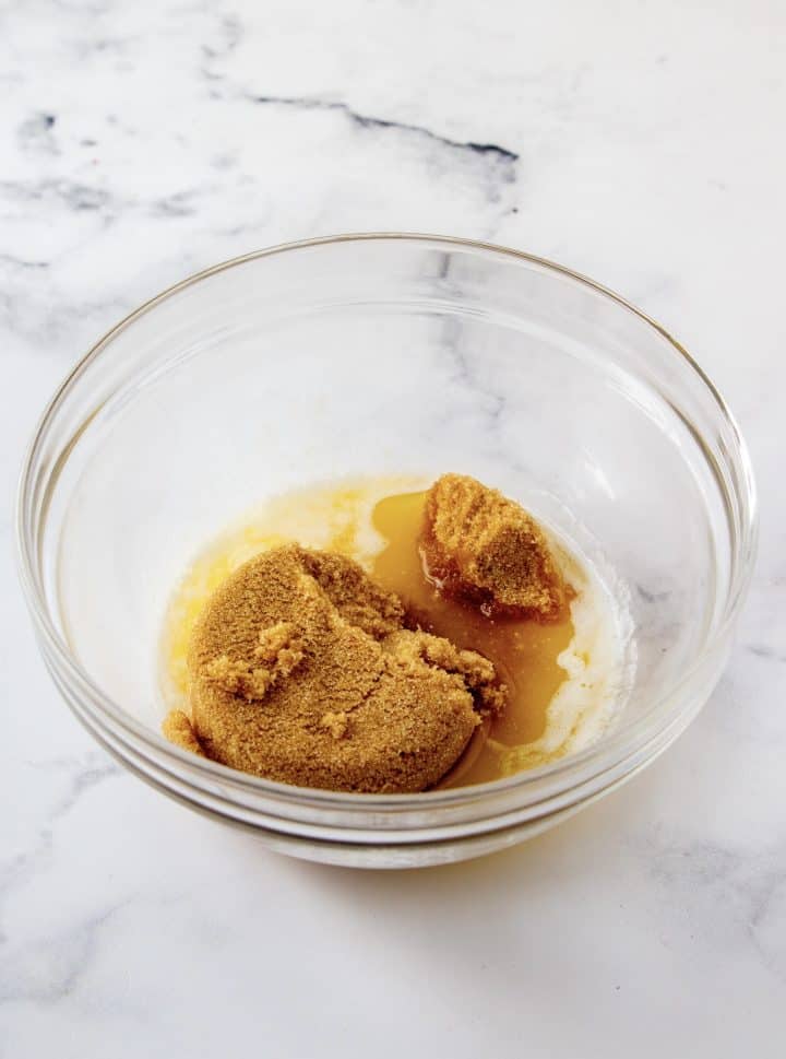 Brown sugar added to melted butter in bowl