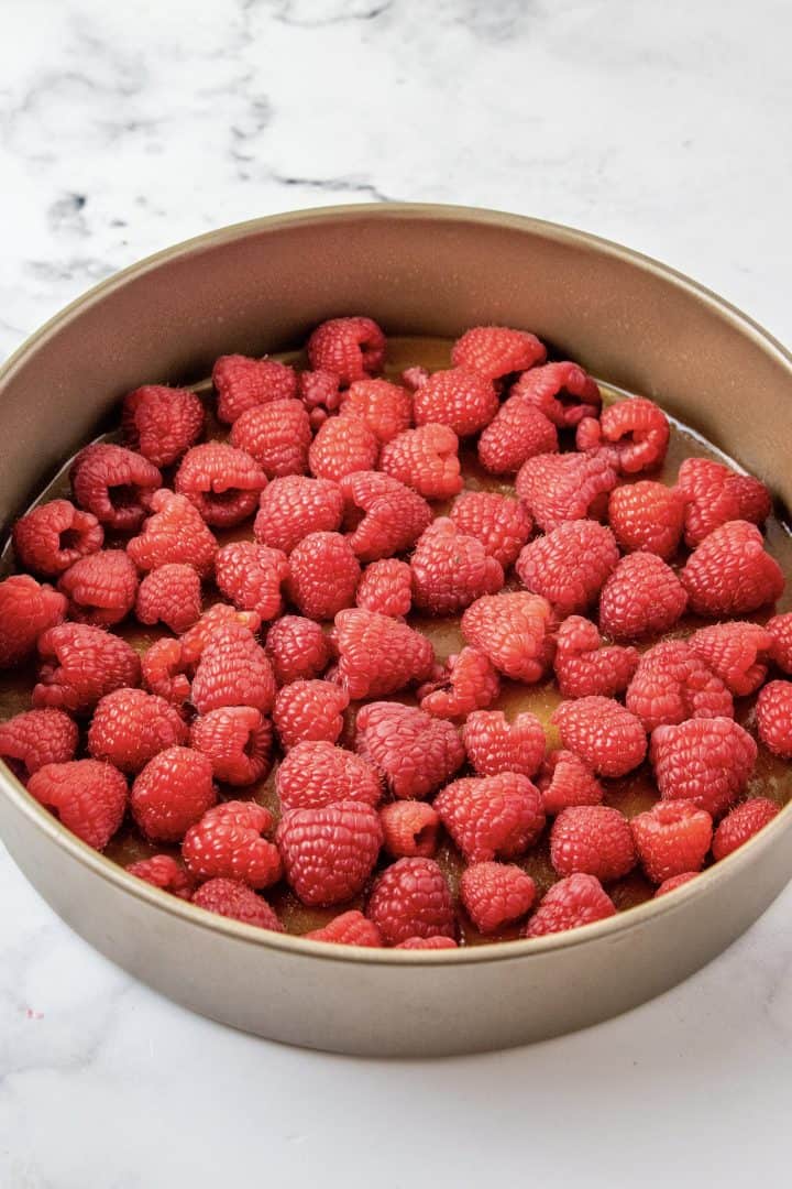 Raspberries on top of brown sugar mixture in pan