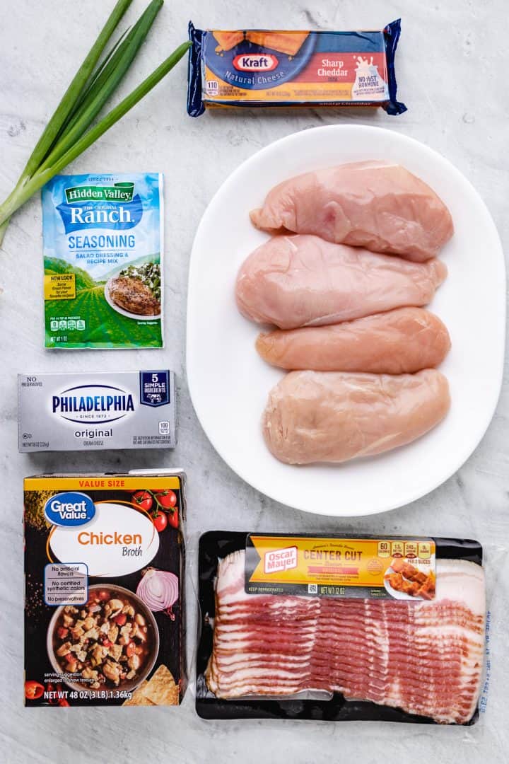 Ingredients needed to make Crock Pot Crack Chicken: chicken breasts, ranch seasoning, cream cheese, chicken broth, cheese, bacon, green onions.