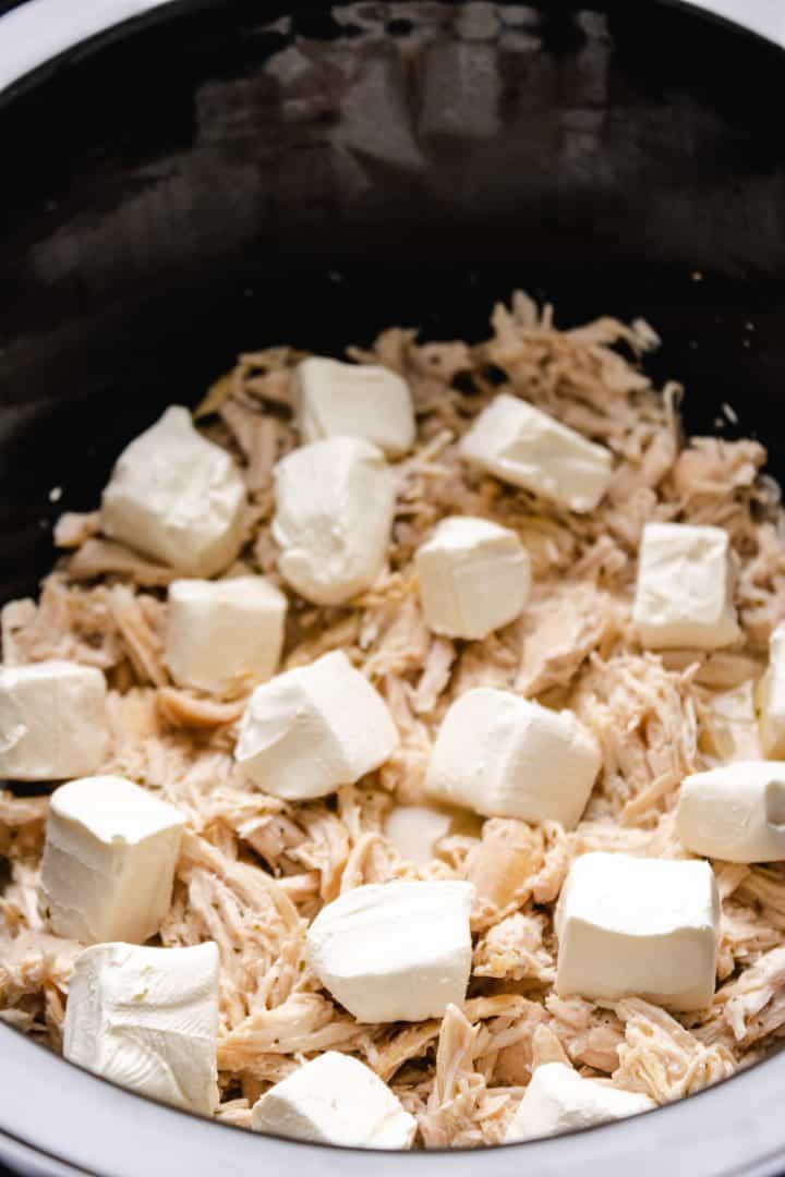 Cubed cream cheese added to crock pot.