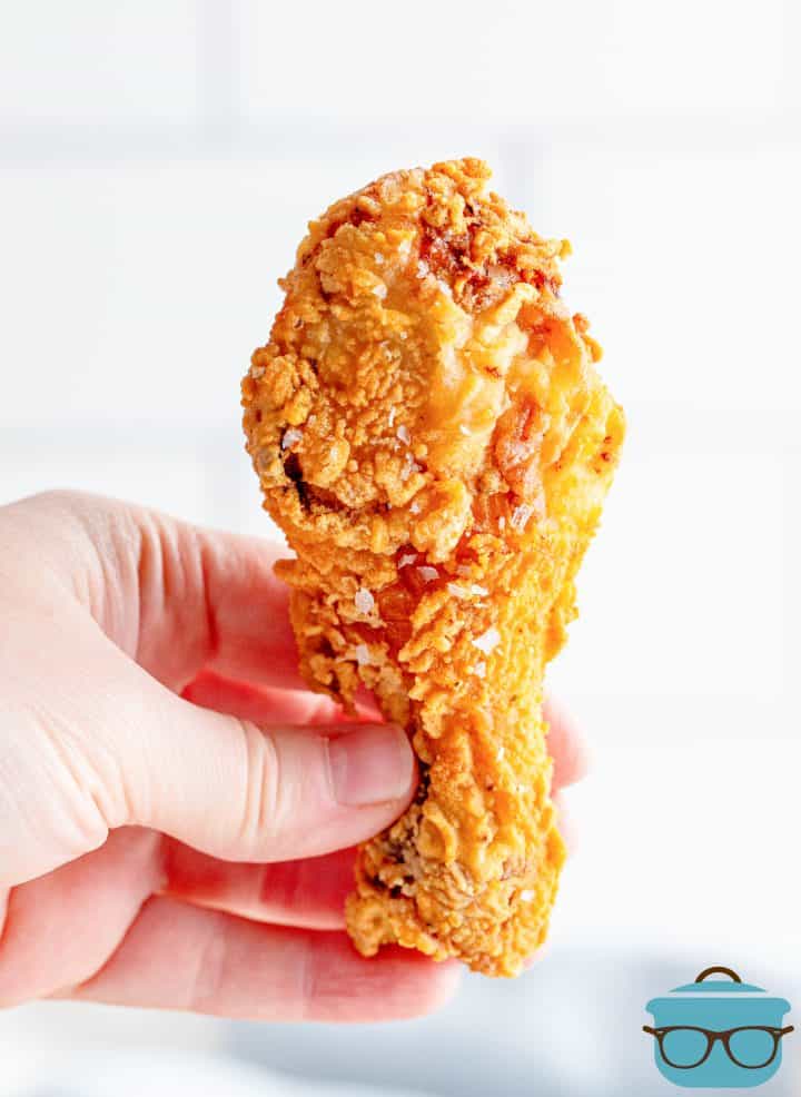 Hand holding a leg piece of Southern Fried Chicken