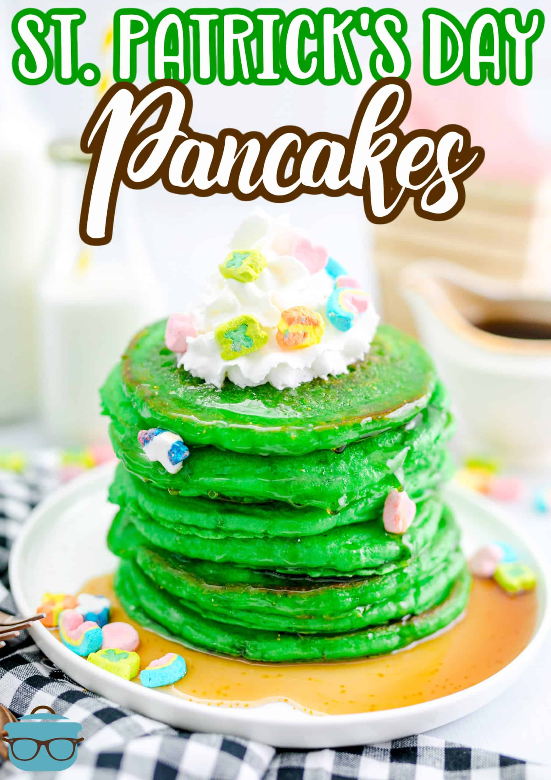 Stacked St. Patrick's Green Pancakes on plate with marshmallows and whipped cream.