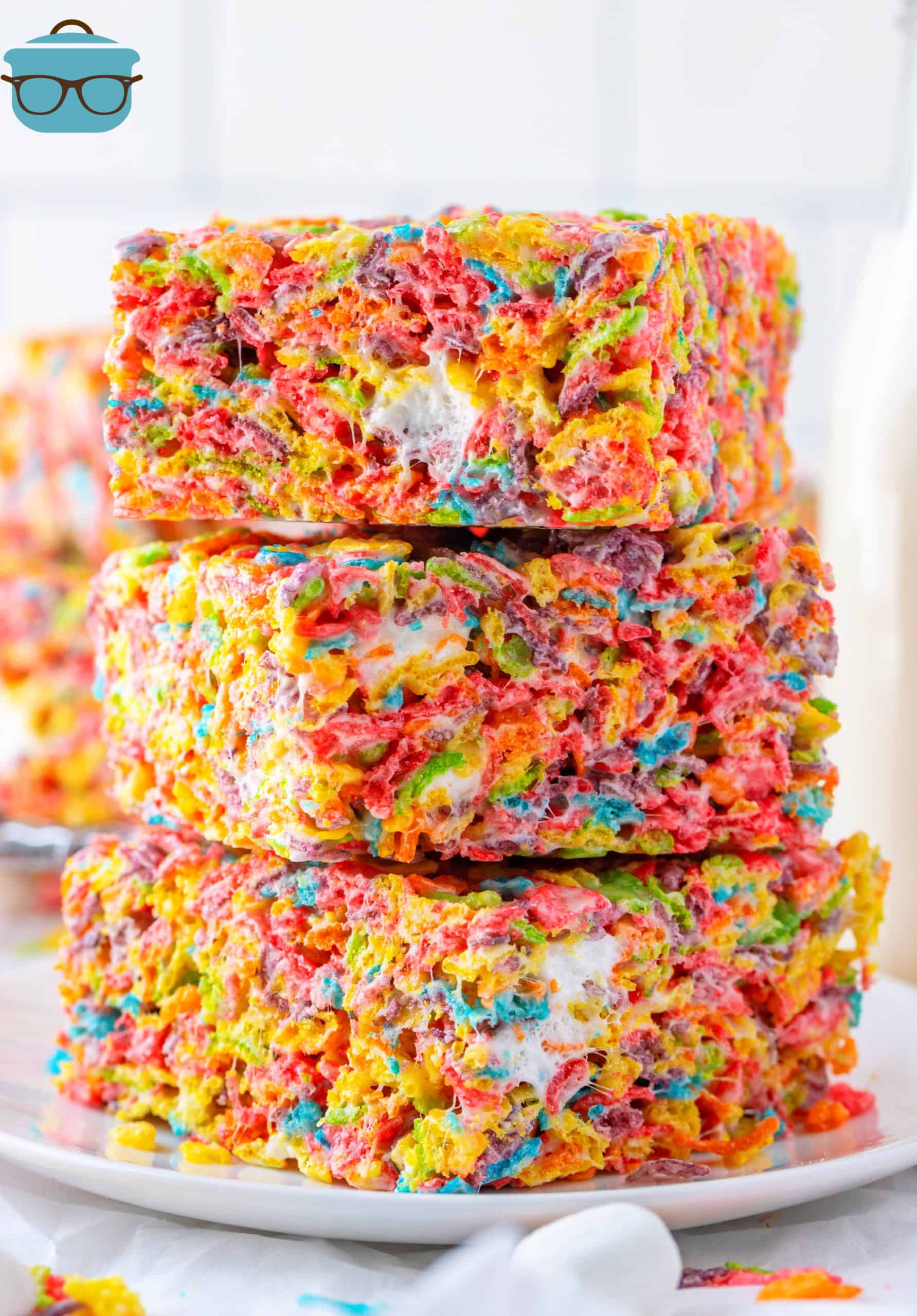 Three stacked Fruity Pebbles Treats on white plate.
