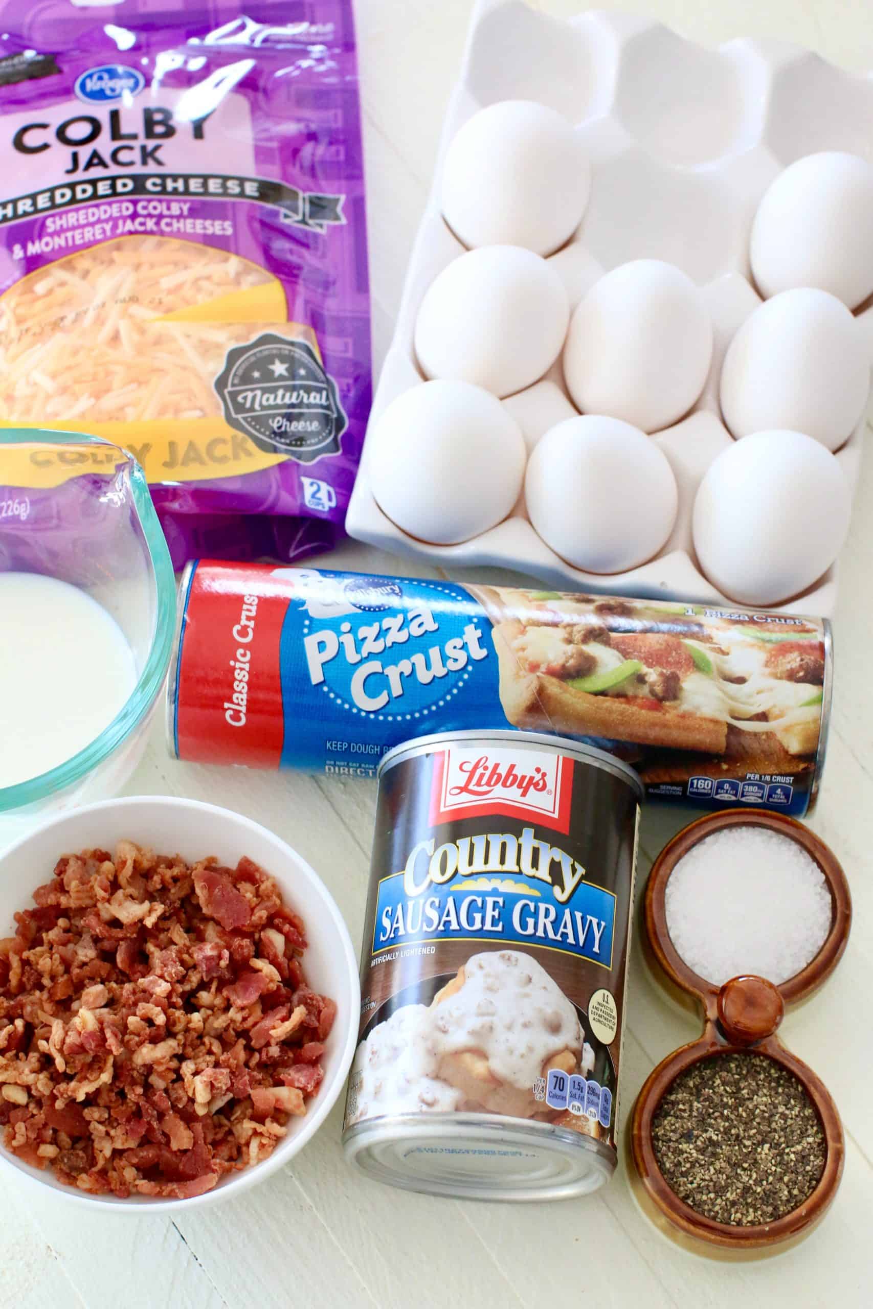 Breakfast Pizza ingredients: refrigerated pizza crust, large eggs, salt snd pepper, milk, Libby's Country Sausage Gravy, shredded Colby jack cheese, bacon pieces.