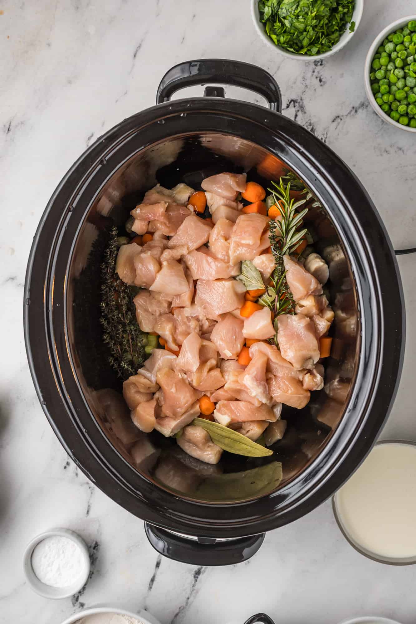 Chicken and herbs added to crock pot.