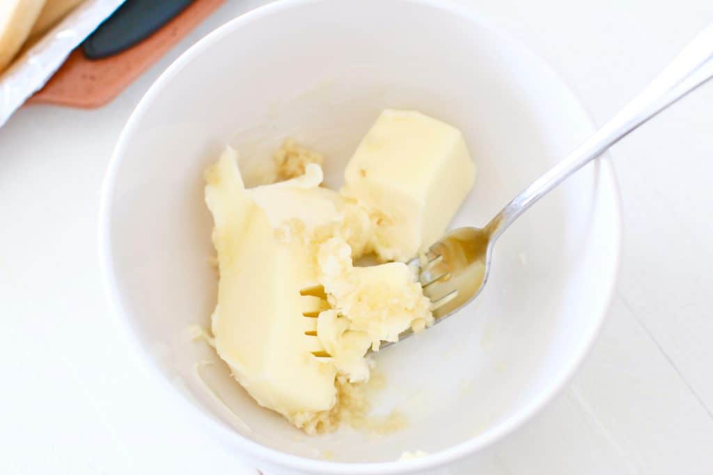 softened butter and minced garlic in a bowl 