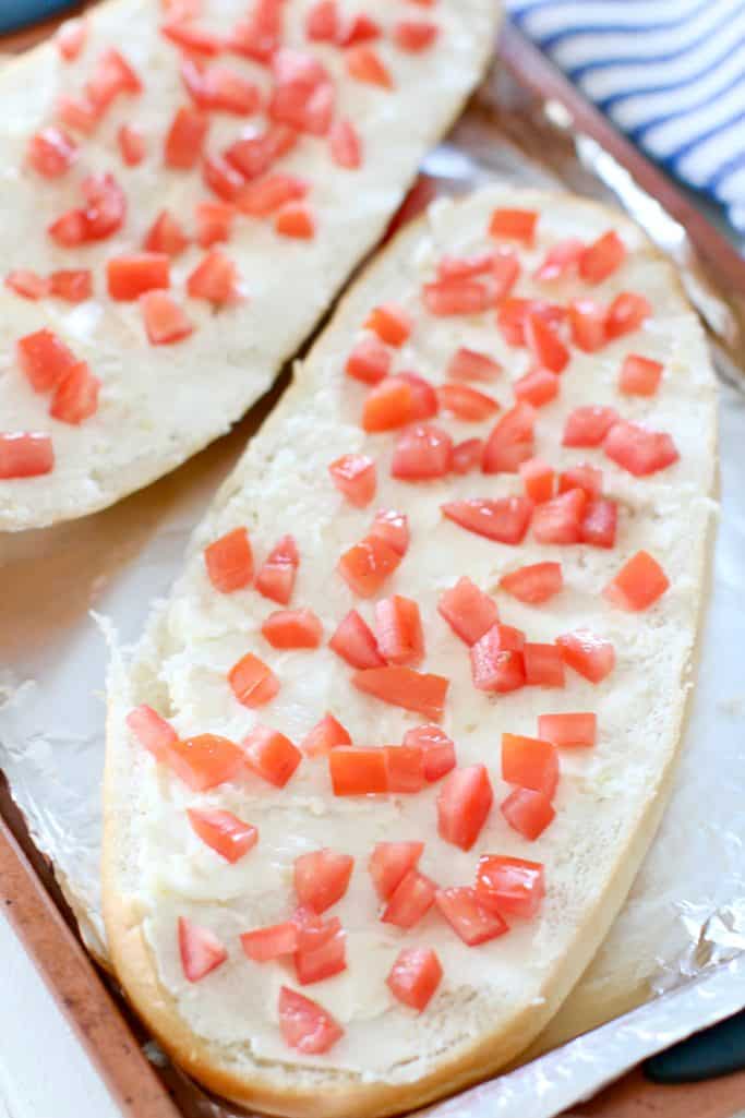 diced tomatoes shown on top of buttered bread