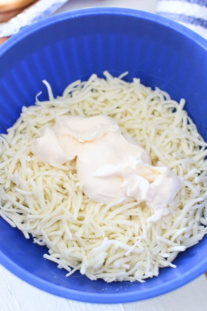 mayonnaise and shredded mozzarella cheese shown in a blue bowl